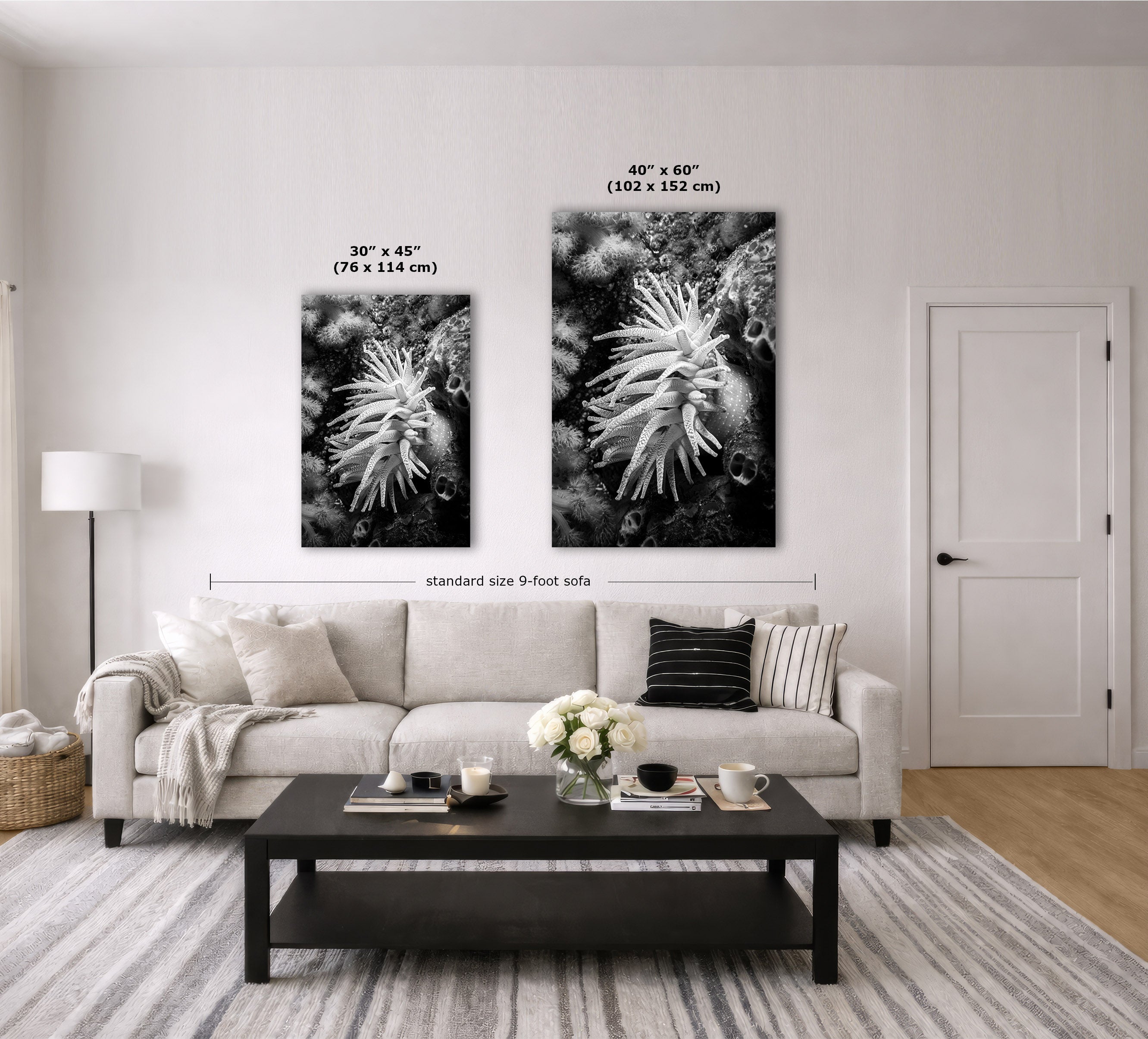 A styled living room showing two black-and-white canvas wall art prints above a sofa, with size labels overlaid: 30 x 45 inches on the left and 40 x 60 inches on the right. The room includes a light sofa, coffee table, lamp, door, and rug.