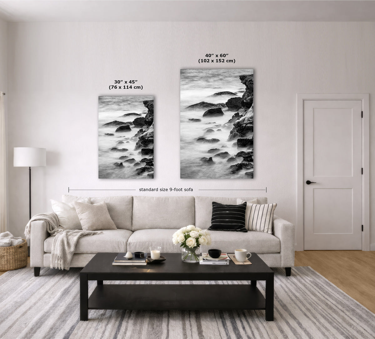 A styled living room showing two black-and-white coastal landscape wall art prints above a light beige sofa. The left print is labeled 30" x 45" (76 x 114 cm), and the larger right print is labeled 40" x 60" (102 x 152 cm), with a dimension line across the sofa indicating standard size 9 feet.