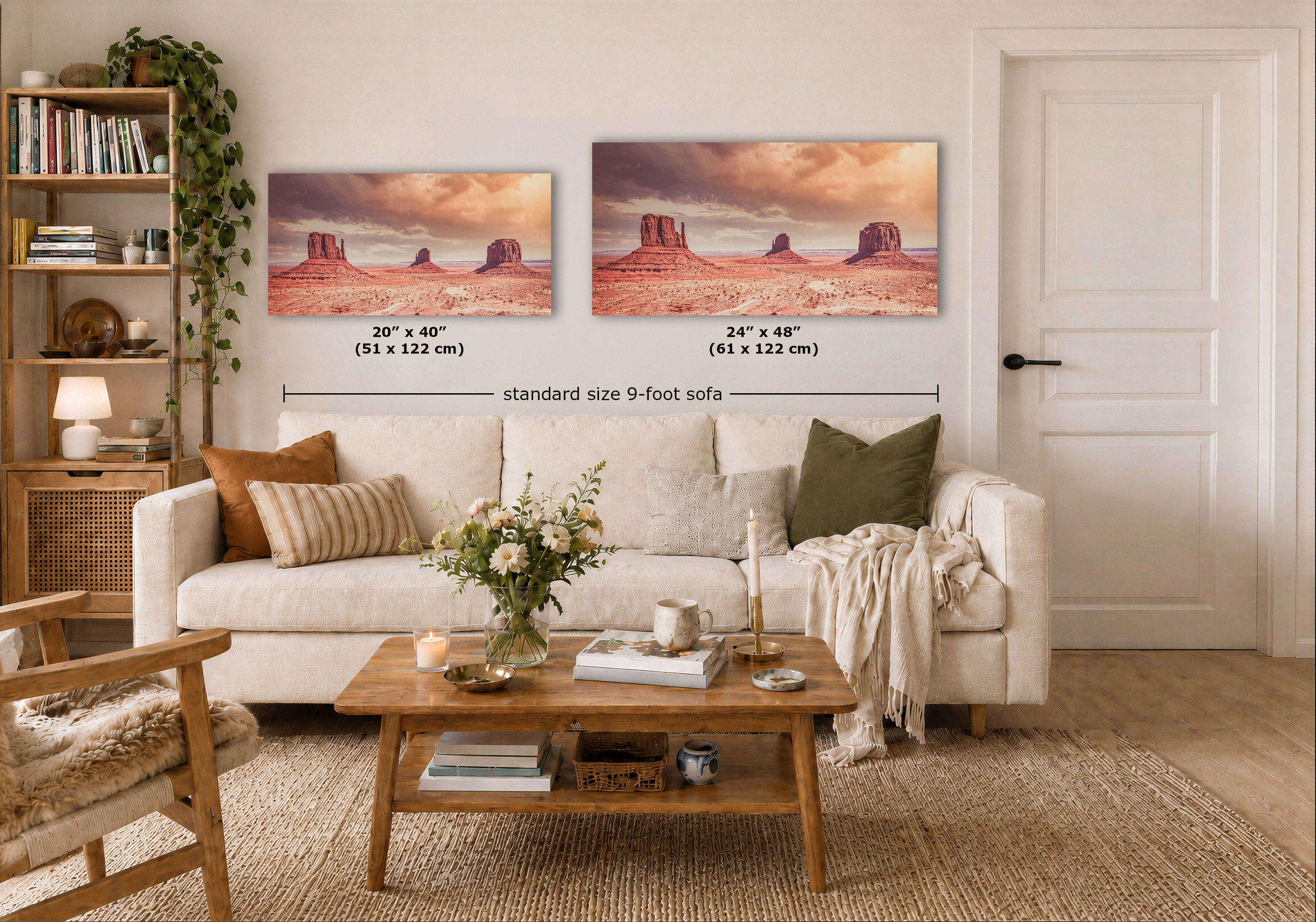 Two desert landscape wall art prints hang above a white sofa in a styled living room. The prints show a warm orange and pink sky over red rock buttes, with size labels reading 20 x 40 in (51 x 122 cm) and 24 x 48 in (61 x 122 cm) and the text 'standard size 9-foot sofa'.