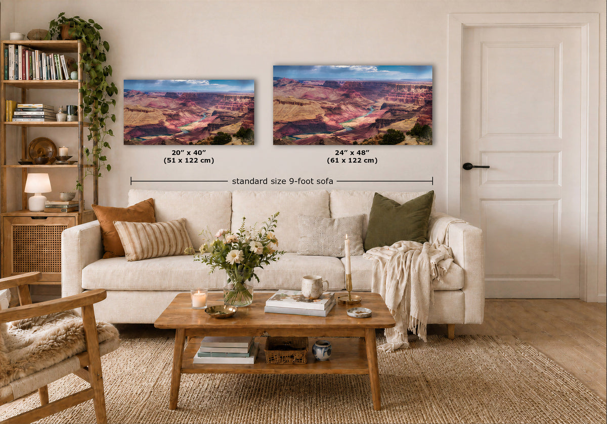 Two landscape wall art prints showing a canyon scene are displayed above a white sofa in a styled living room. Black dimension lines and text indicate the sizes of the prints and note a standard size 9-foot sofa.
