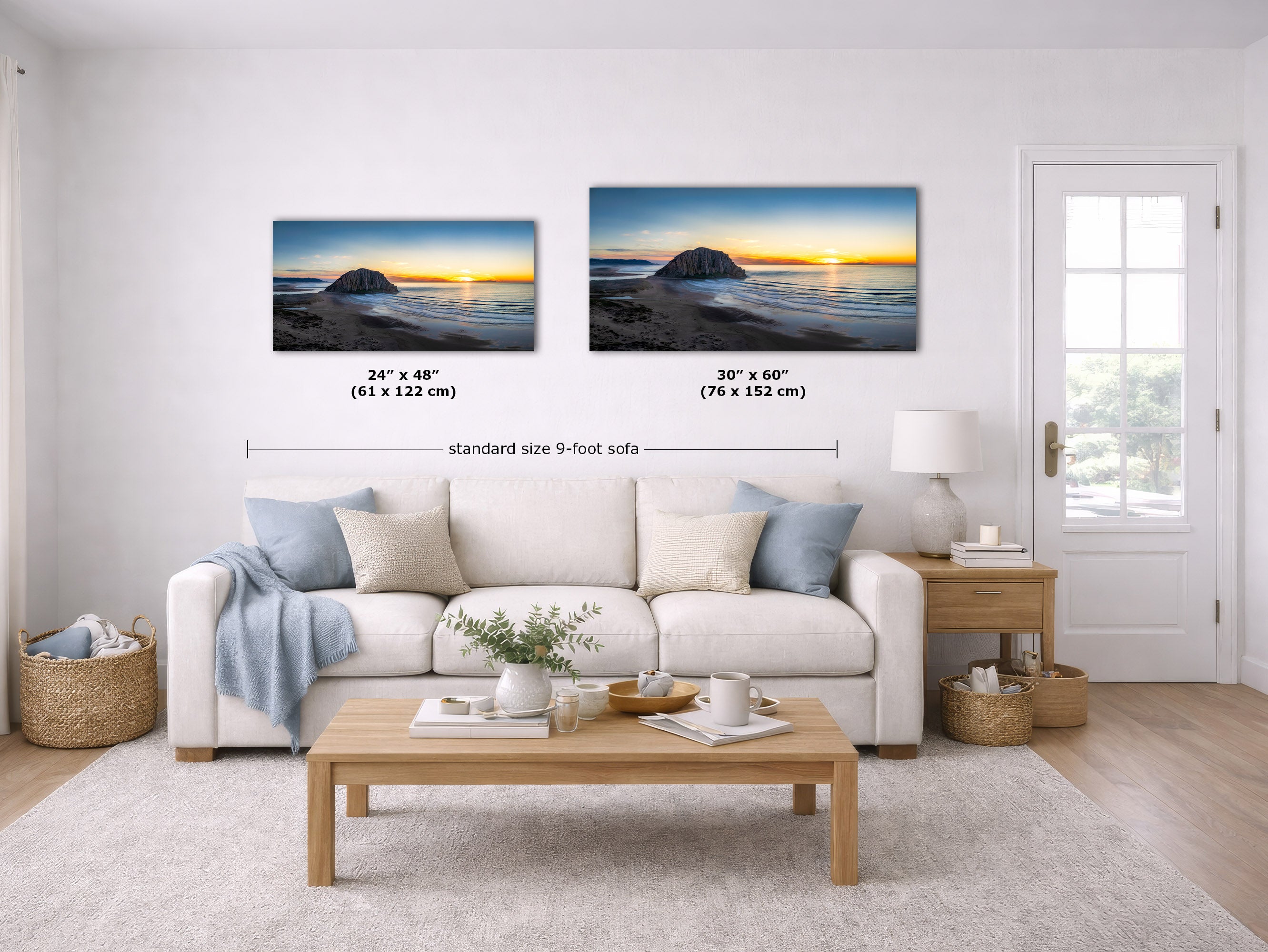 A staged living room shows two wall art prints above a white sofa. The prints depict a rocky shoreline at sunset, with one smaller version labeled 24 x 48 in (61 x 122 cm) and one larger version labeled 30 x 60 in (76 x 152 cm).