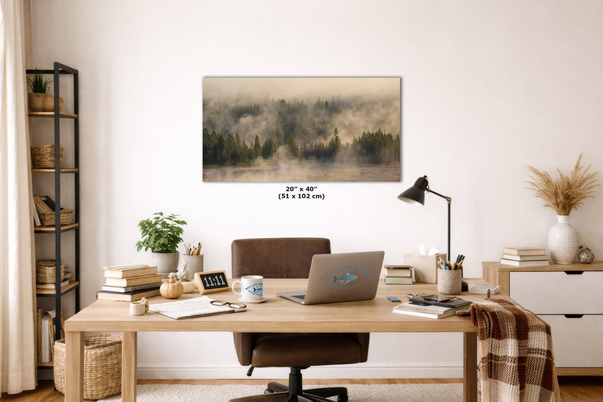 A rectangular wall art print showing a misty forest landscape in muted green, brown, and beige tones, displayed above a wooden desk in a styled home office interior. Small text below the print reads 20" x 40" (51 x 102 cm).