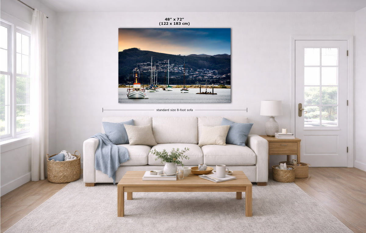 A wall art print showing a harbor scene at dusk is displayed above a white sofa in a bright, modern living room. The image includes dimension markers indicating the print is 48 x 72 inches.