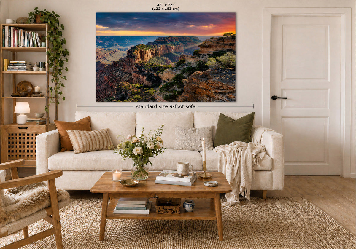 A large rectangular wall art print showing an Arizona desert canyon landscape at sunset hangs above a white sofa in a styled living room. The print includes size text reading 48 x 72 inches and a dimension callout for a standard 9-foot sofa.
