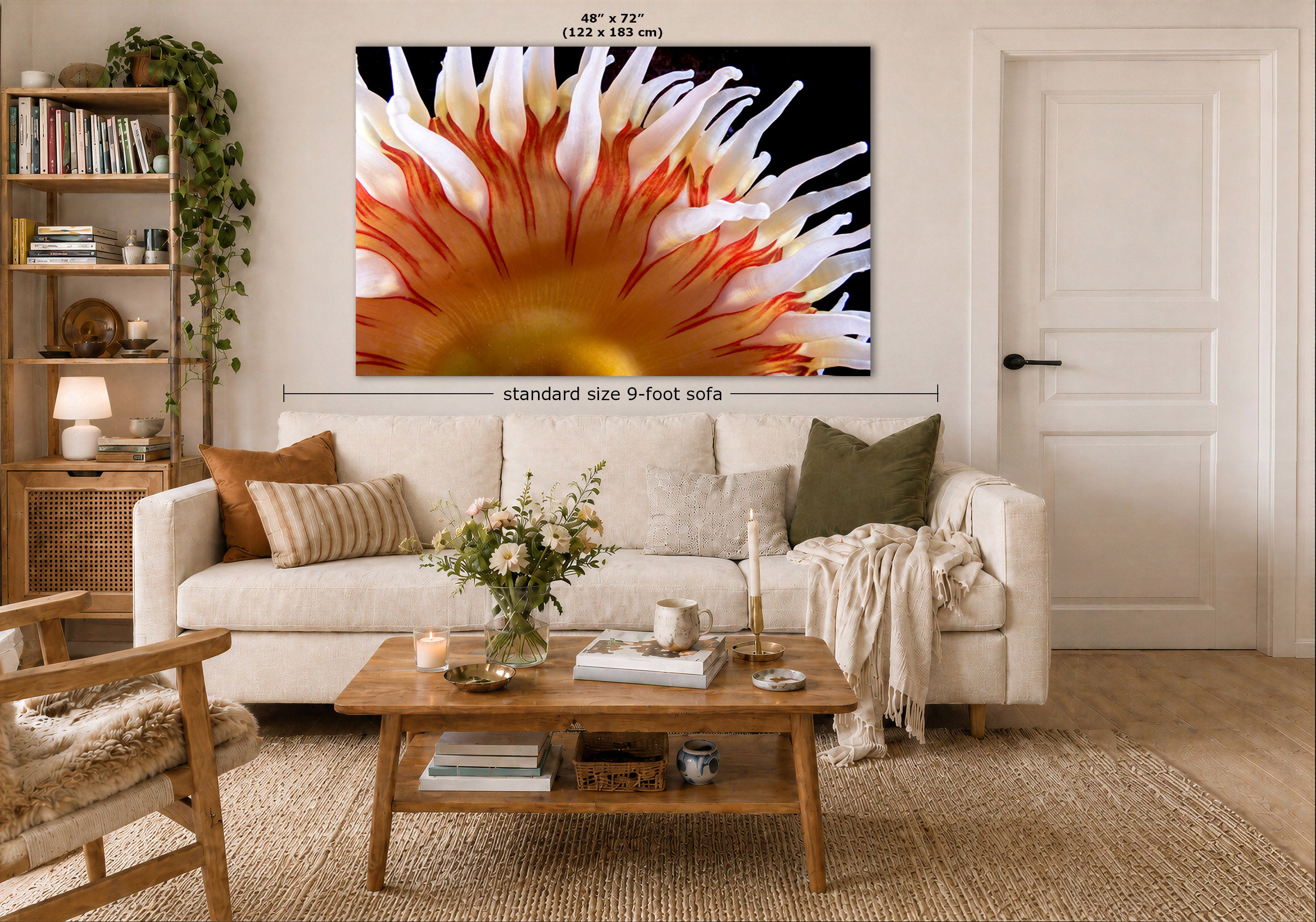 A large wall art print showing a close-up underwater design in black, white, orange, and yellow, displayed above a white sofa in a styled living room. Measurement text and arrows indicate the print size as 48 x 72 inches (122 x 183 cm) and note standard size 9-foot sofa context.
