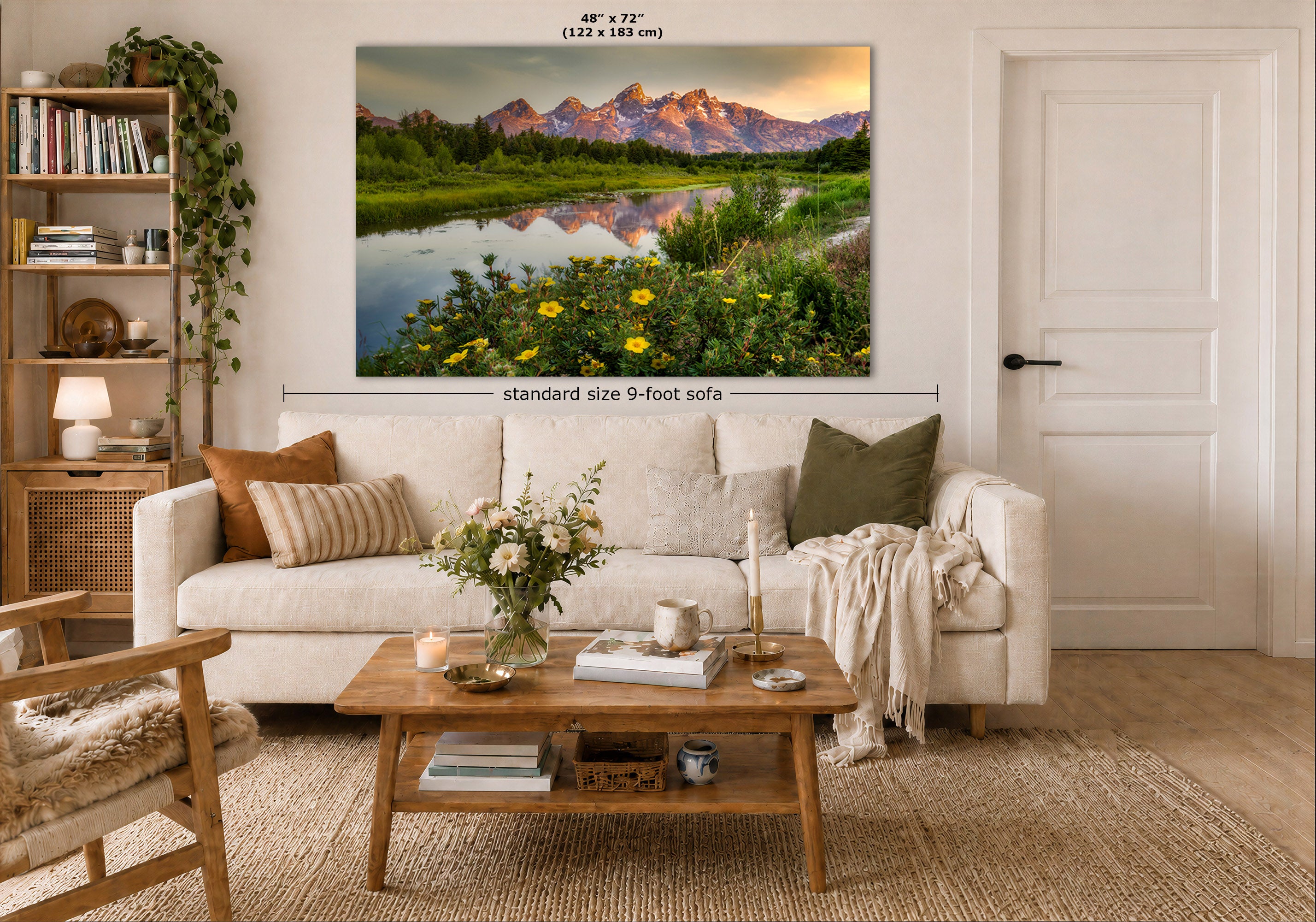 A large wall art print showing a mountain landscape with yellow wildflowers is displayed above a white sofa in a styled living room. The image includes dimension labels indicating 48 x 72 inches and a note about the standard size 9-foot sofa.