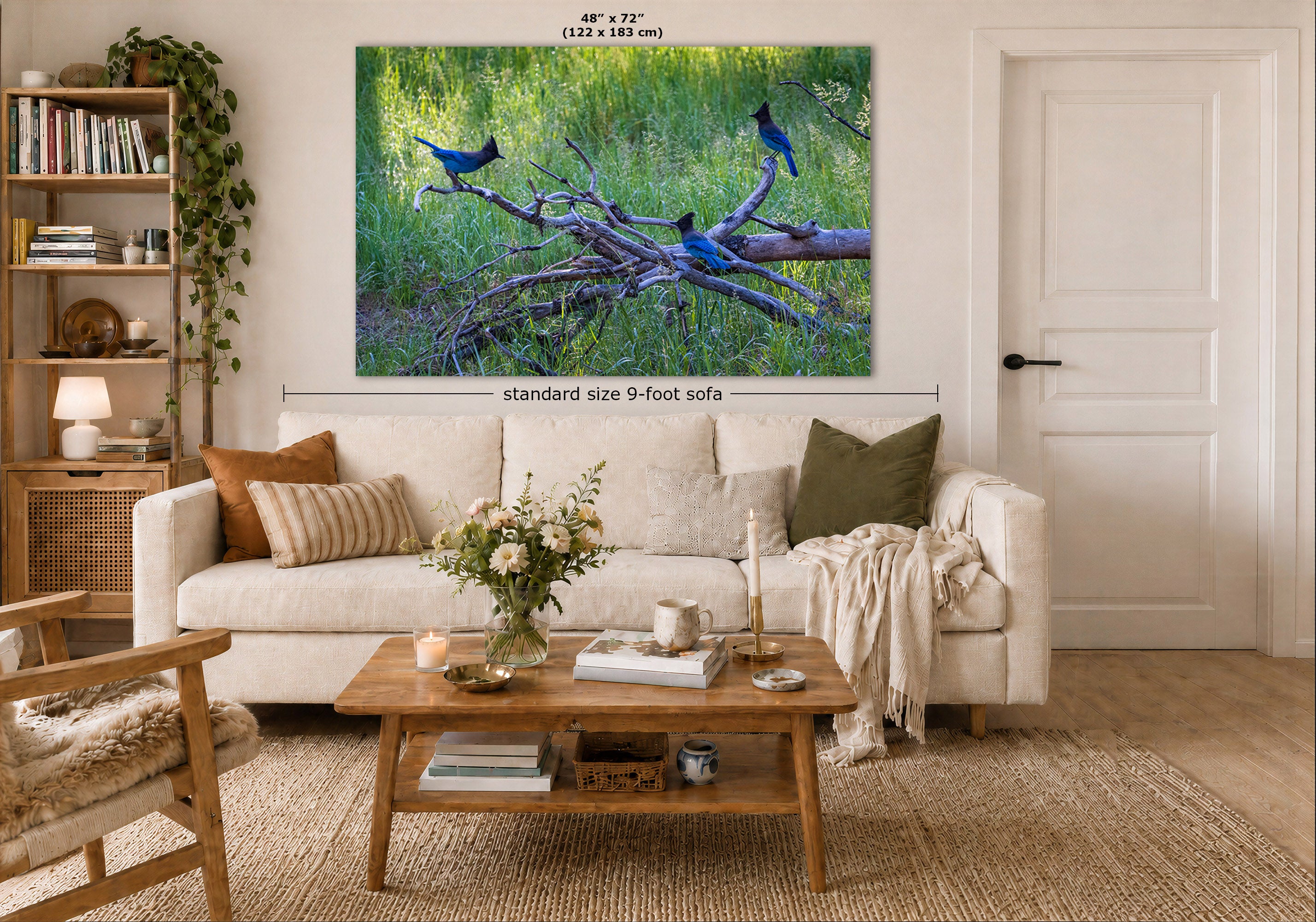 A large wall art print showing blue birds perched on branches in a green forest is displayed above a white sofa in a styled living room. The image includes dimension labels indicating the print is 48 x 72 inches and the sofa is standard size 9-foot.