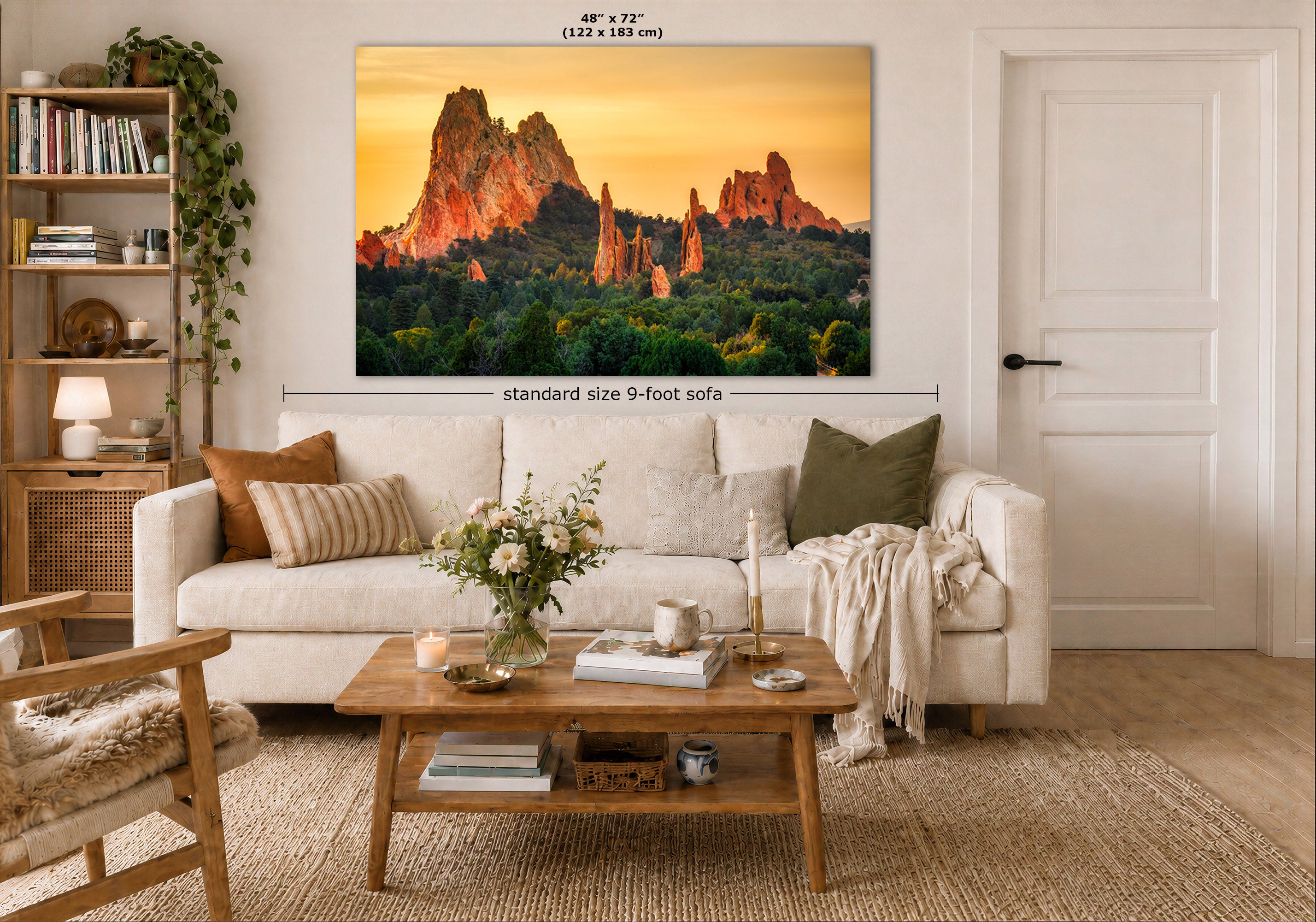 A large wall art print showing a desert rock formation landscape at sunset, displayed above a white sofa in a styled living room. The print includes size labels reading 48" x 72" and a note about standard size 9-foot sofa placement.