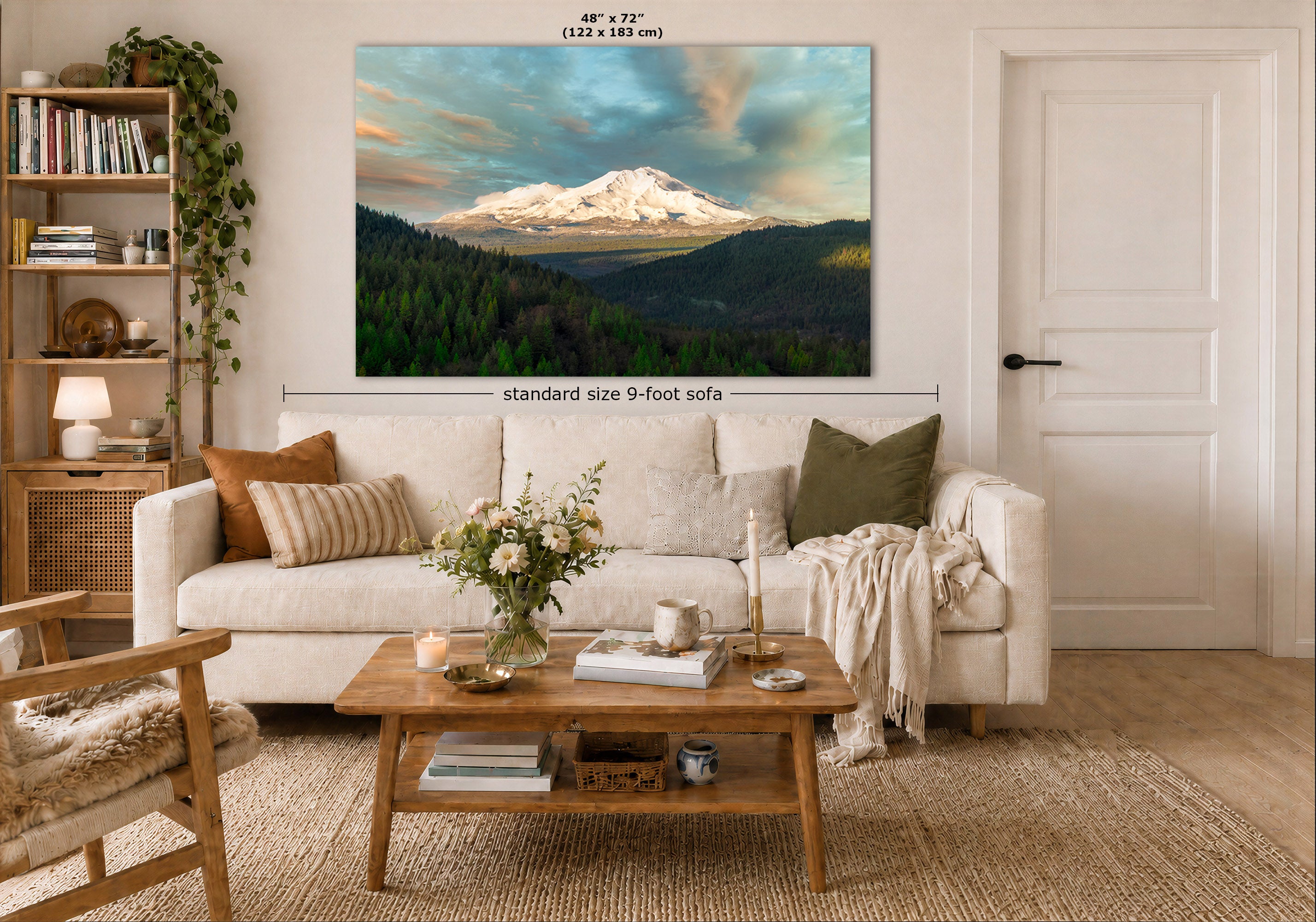 A large wall art print showing a snow-capped mountain landscape is displayed above a white sofa in a styled living room. The print includes size markings reading 48" x 72" and a dimension label for a standard size 9-foot sofa.