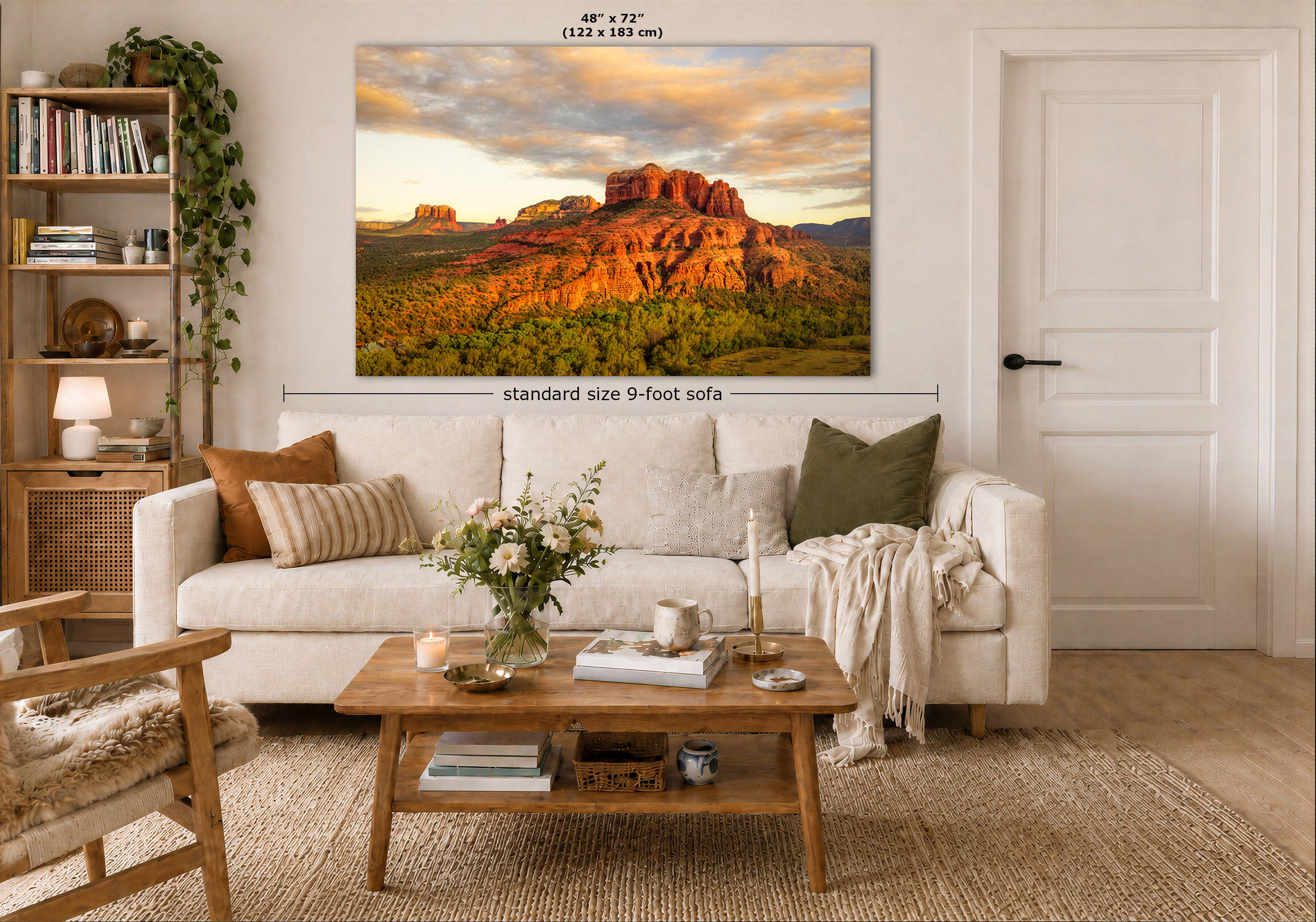 A large wall art print showing a desert rock landscape at sunset hangs above a white sofa in a styled living room. The image includes size labels indicating 48 x 72 inches and a note about standard size 9-foot sofa placement.