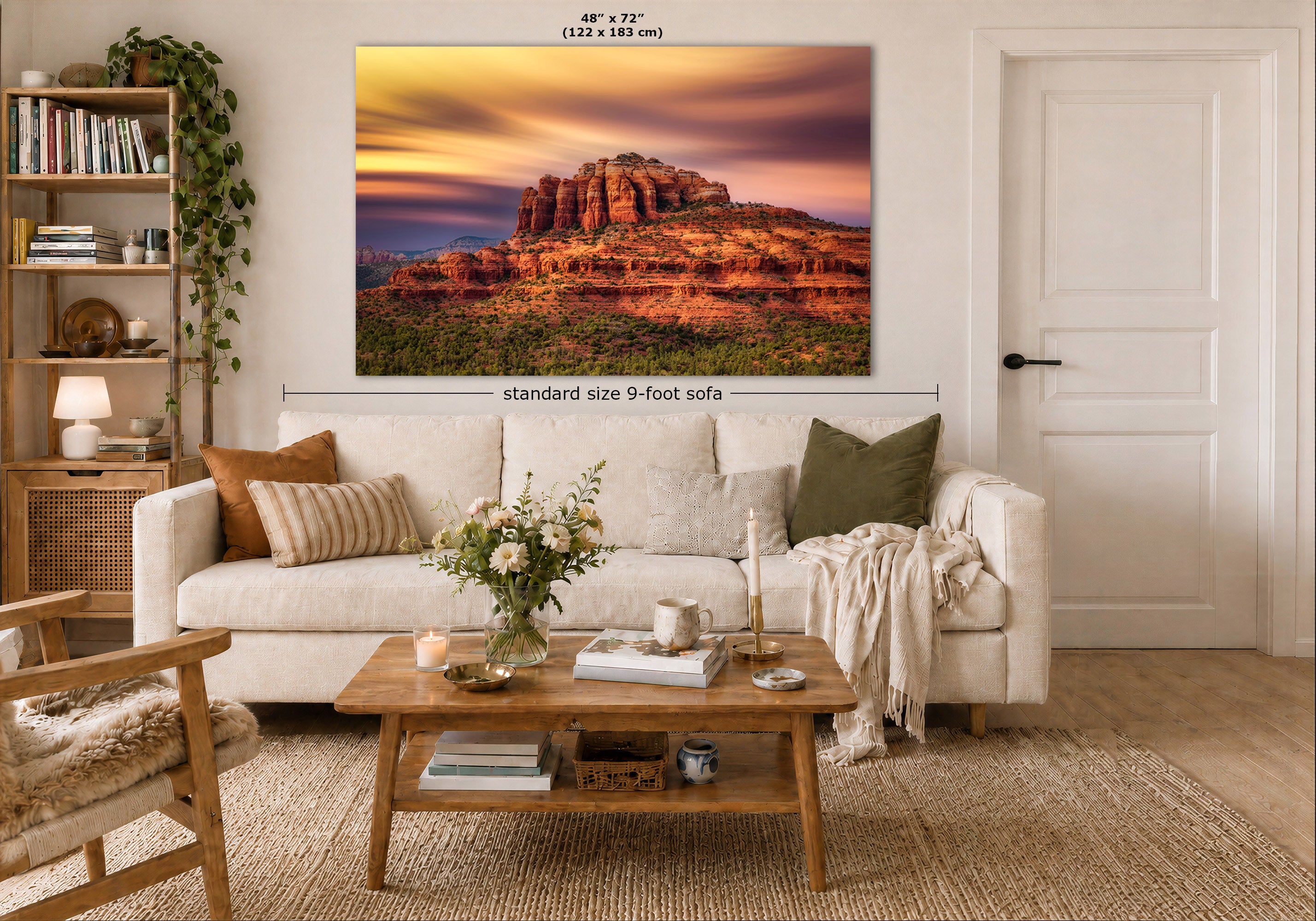 A framed wall art print showing a desert rock landscape at sunset hangs above a white sofa in a styled living room. The image includes dimension labels indicating the print is 48 x 72 inches and the sofa is standard size 9-foot wide.