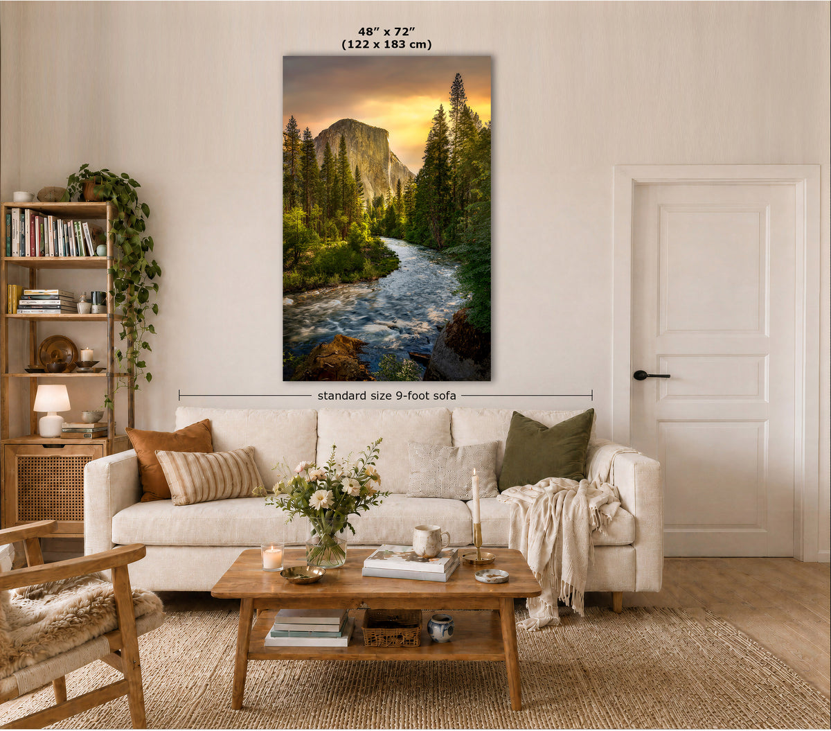 A vertical El Capitan sunrise wall art print showing the Merced River at sunrise, displayed above a white sofa in a styled living room. Text on the image indicates the size is 48" x 72" (122 x 183 cm) and notes standard size 9-foot sofa.