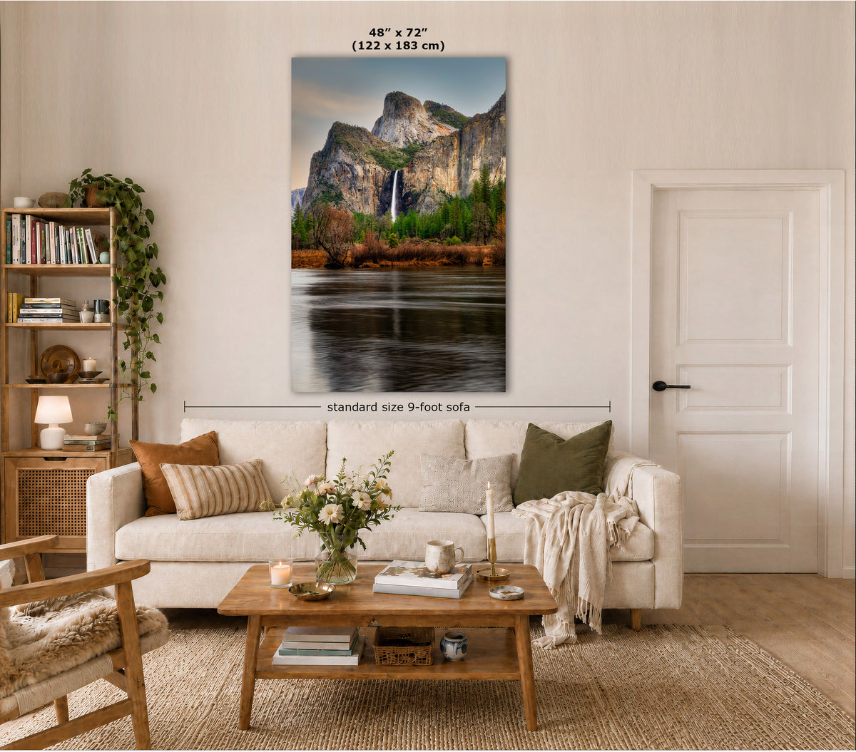 A large vertical wall art print showing a mountain landscape with a waterfall and reflective water, displayed above a cream sofa in a styled living room. Text on the image indicates the print size as 48" x 72" (122 x 183 cm) and notes standard size 9-foot sofa context.