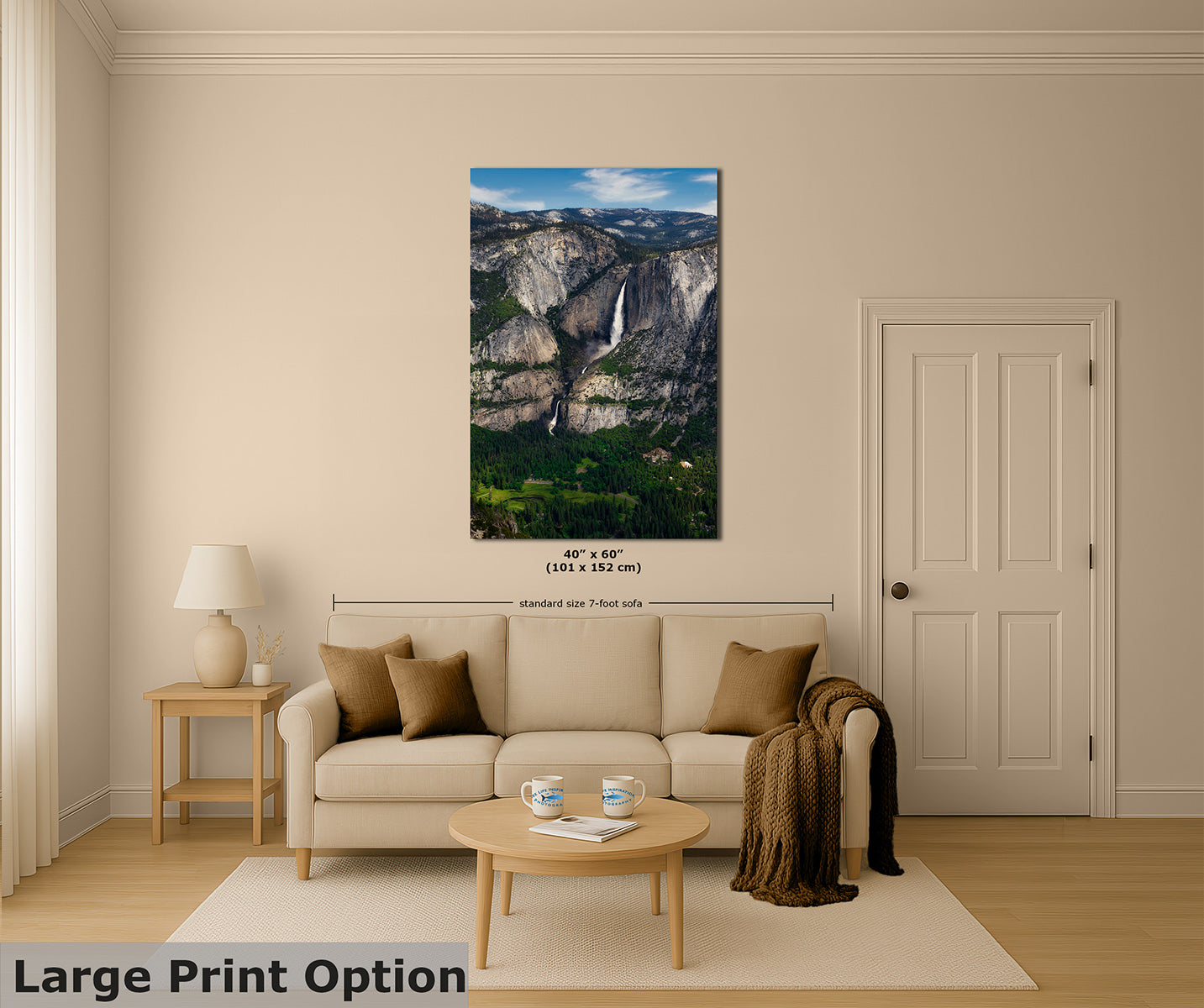 A wall-decor print depicting a mountain landscape with Yosemite Falls is displayed above a beige sofa in a styled living room. The print includes dimension markings, and the text 'Large Print Option' appears in the lower left corner.