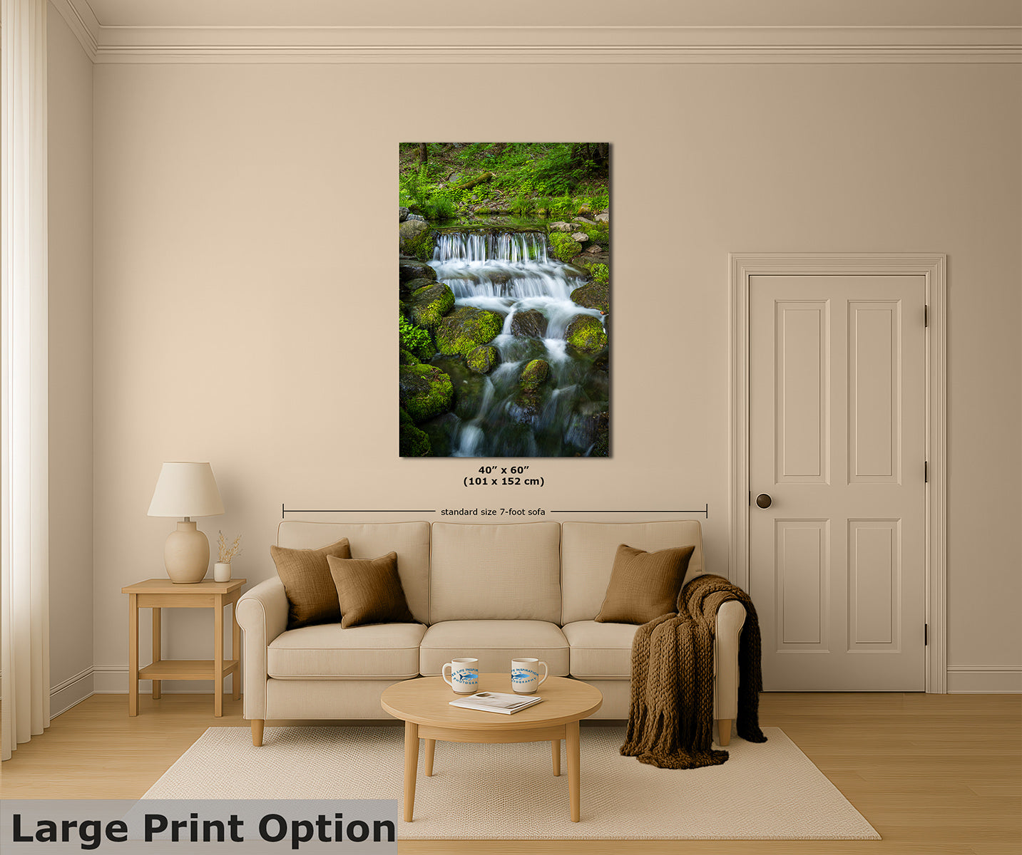 A framed wall art print showing a lush green forest stream with a small waterfall, displayed above a beige sofa in a styled living room. The print includes dimension markings, and a text overlay at the bottom reads 'Large Print Option'.