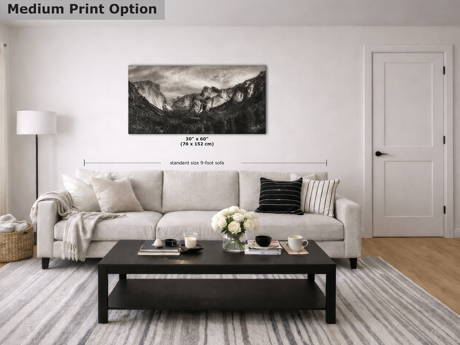 A black-and-white Yosemite mountain landscape print displayed above a light sofa in a staged living room, with overlaid dimension text reading 30" x 60" (76 x 152 cm) and a label for the medium print option.