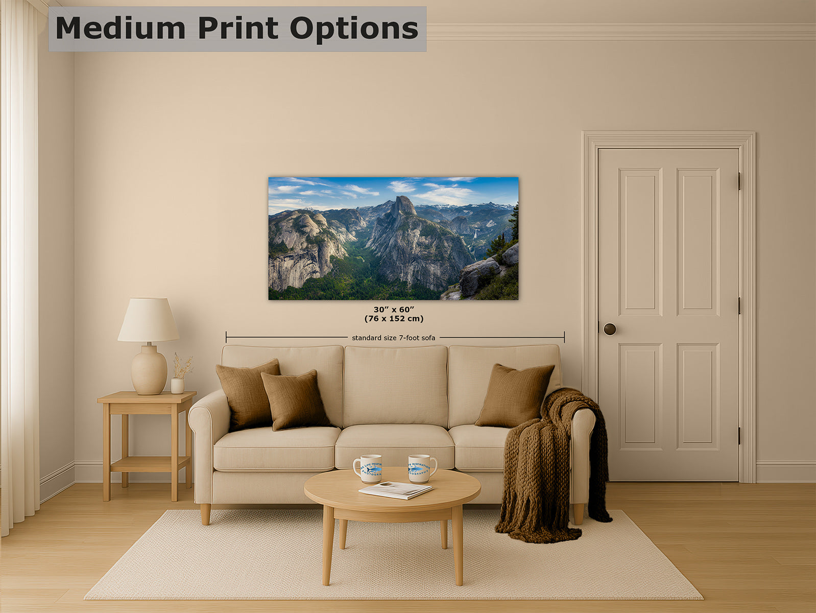 A frameless landscape wall art print depicting Half Dome under a blue sky, displayed above a beige sofa in a styled living room. The image includes the text 'Medium Print Options' and size annotations below the artwork.