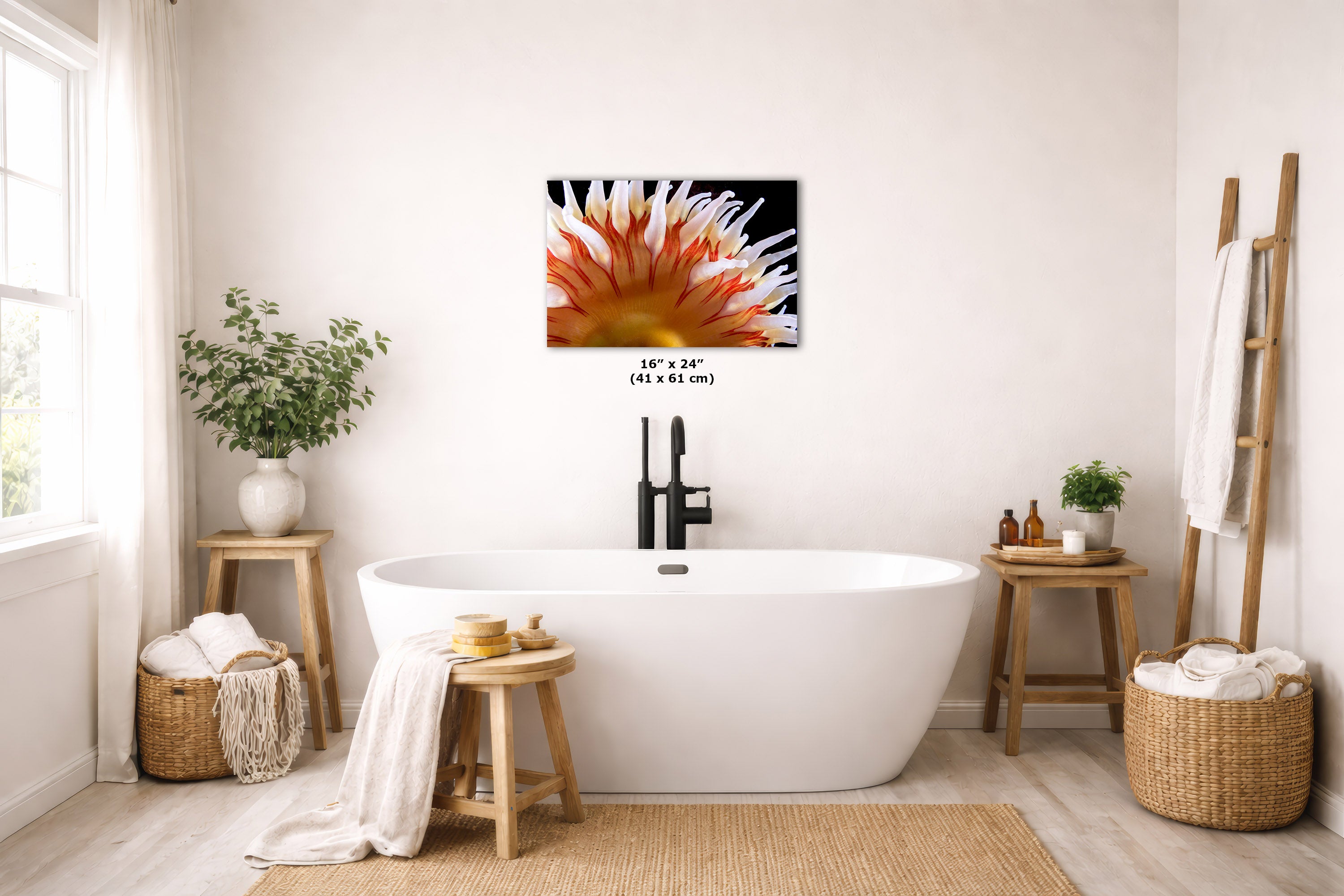 A freestanding bathtub in a bright, neutral-toned bathroom with a wall-mounted underwater artwork hanging on the wall. The room includes wooden stools, woven baskets, plants, and a ladder-style towel rack.