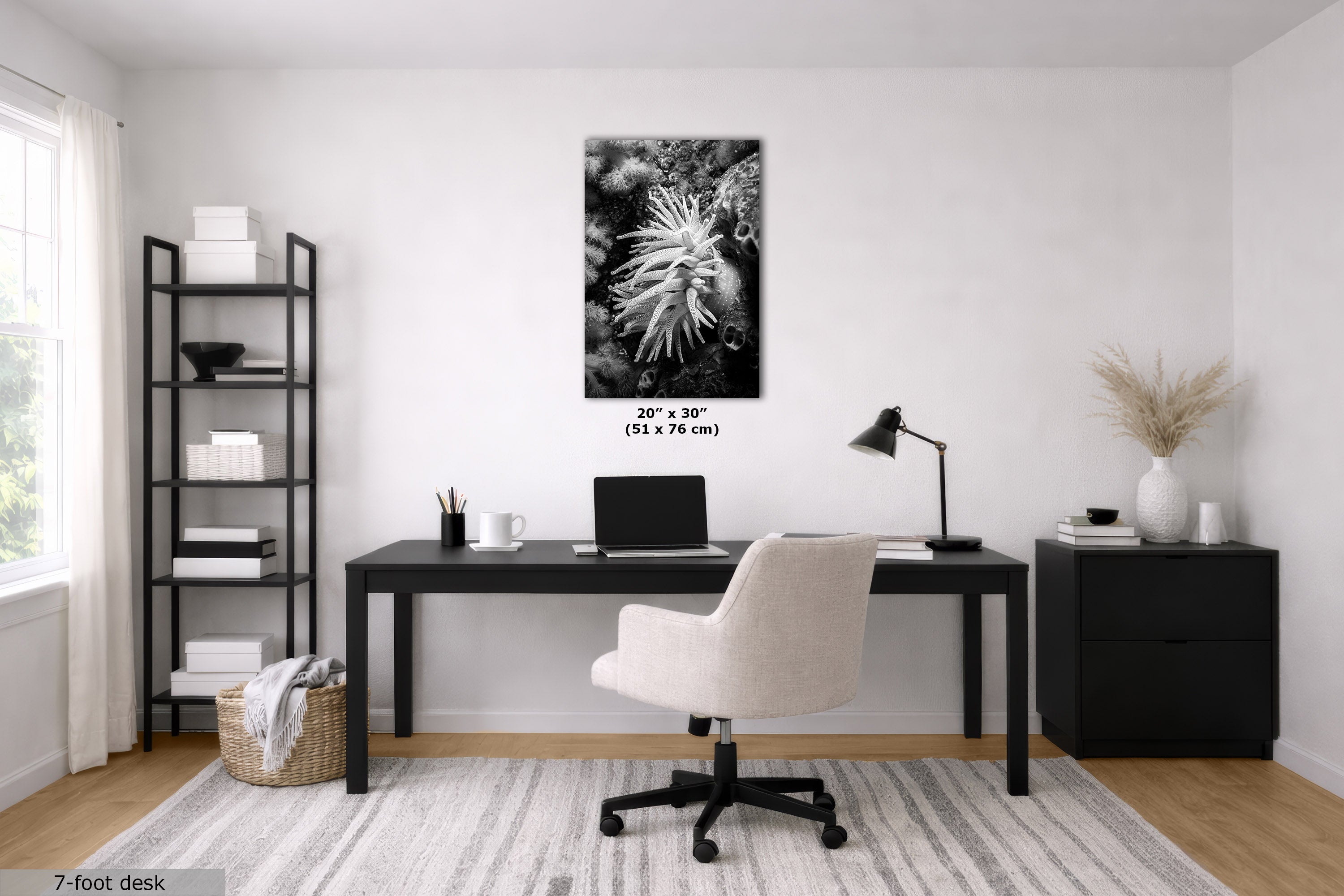 A styled home office interior featuring a black desk, cream swivel chair, shelving, and a black-and-white floral wall art print centered on a white wall. The print includes size text reading 20 x 30" (51 x 76 cm).