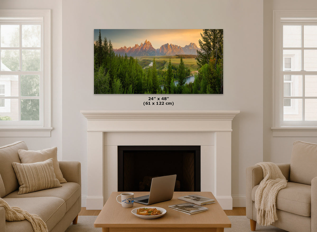 A framed wall art print showing a mountain landscape at sunset hangs above a white fireplace in a bright living room. The print includes a size label reading 24 x 48 inches (61 x 122 cm).