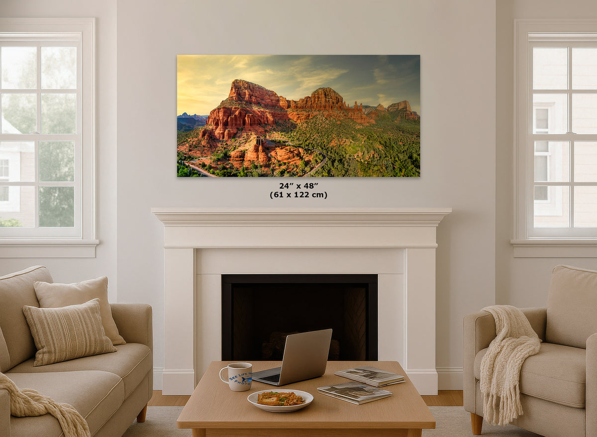 A wall art print showing a desert mountain landscape hangs above a white fireplace in a bright living room. The print includes size text reading 24 x 48 inches (61 x 122 cm).
