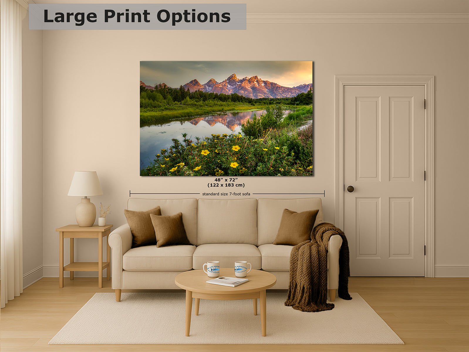 A large wall art print showing the Grand Teton Mountains with yellow wildflowers and sunset tones, displayed above a beige sofa in a styled living room. Text at the top reads 'Large Print Options' and size text below the print indicates 48 x 72 inches.