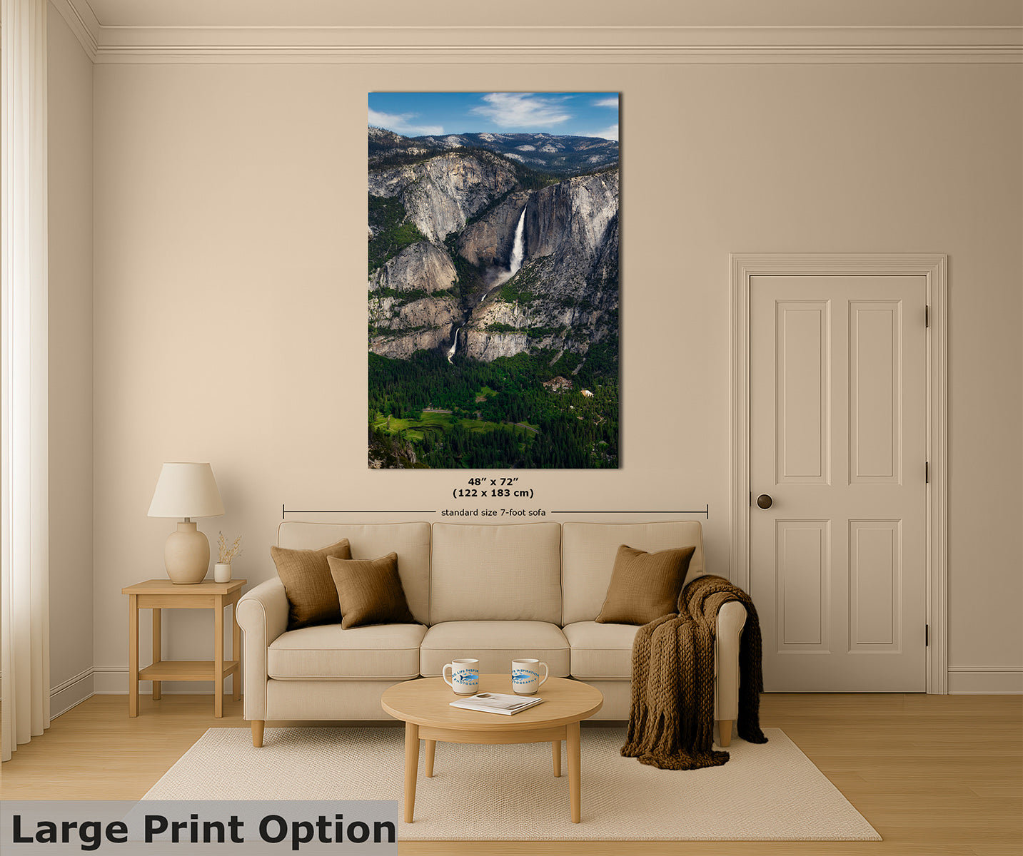 A large vertical wall art print depicting a Yosemite Falls mountain landscape, displayed above a beige sofa in a styled living room. The print includes size text reading 48 x 72 inches, and the room scene includes a side table, lamp, coffee table, and door.
