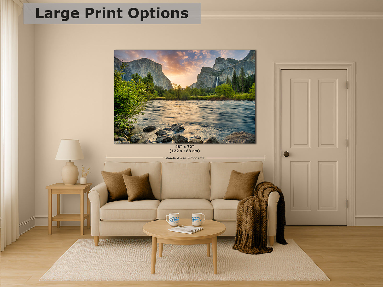 A large wall art print showing a mountain river landscape with trees and a sunset, displayed above a beige sofa in a styled living room. The image includes text reading 'Large Print Options' and size information for the print.