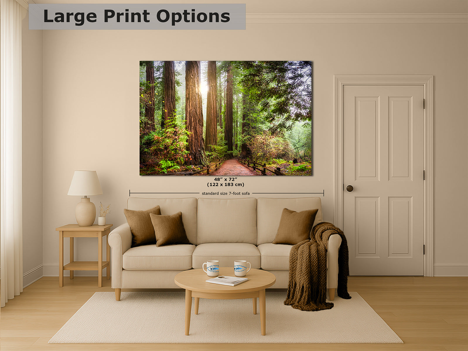 A large wall art print showing a sunlit California Redwood forest path hangs above a beige sofa in a styled living room.