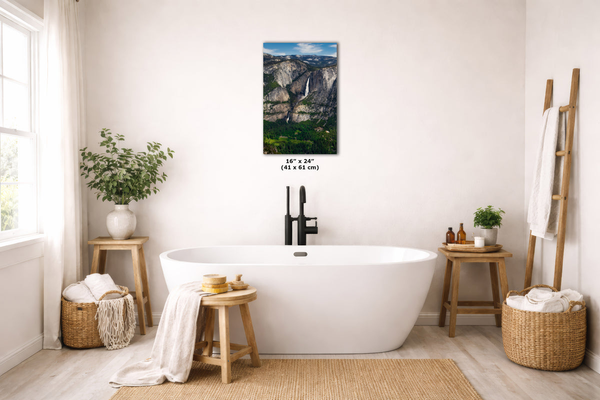 A wall art print depicting a waterfall landscape is displayed above a freestanding white bathtub in a bright, modern bathroom. The print includes a size measurement overlay reading 16 x 24 inches (41 x 61 cm).