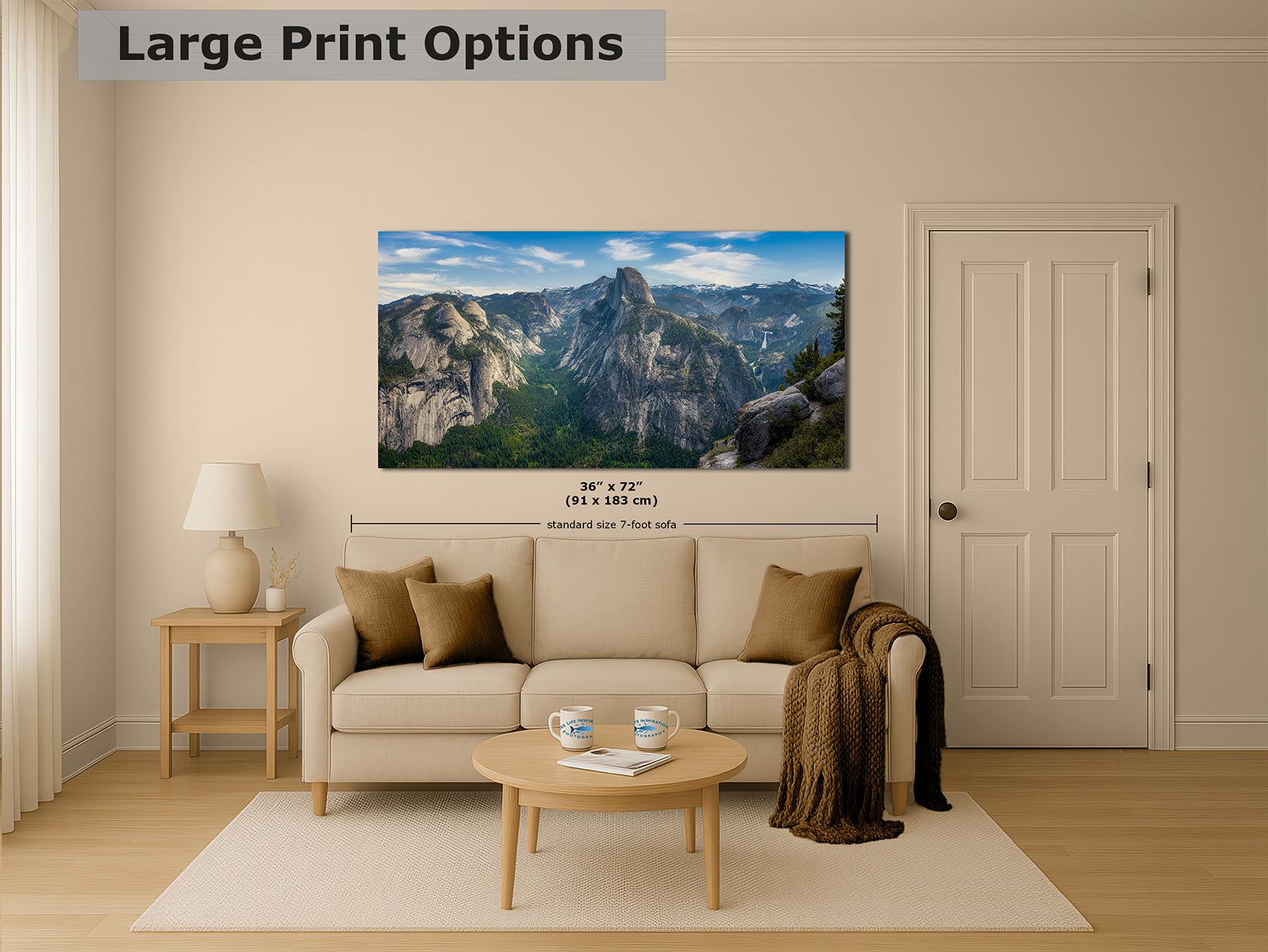 A large Yosemite landscape wall print showing the mountain peak of Half Dome under a blue sky, displayed above a beige sofa in a styled living room. The image includes text reading 'Large Print Options' and size information overlaid near the print.
