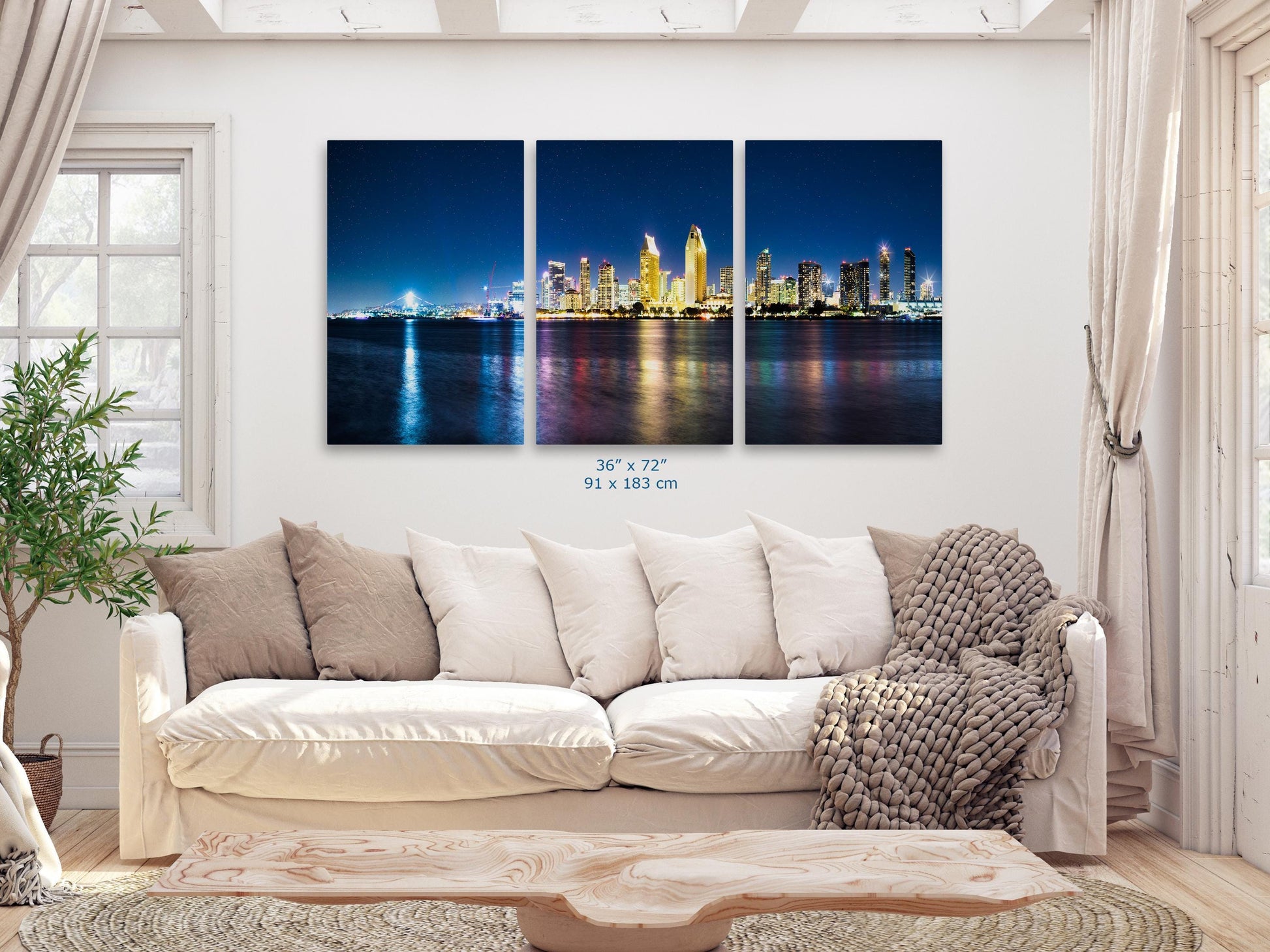 Triptych wall art of San Diego skyline in a living room, 36x72 inch, showing the vibrant city lights and water reflections at night.