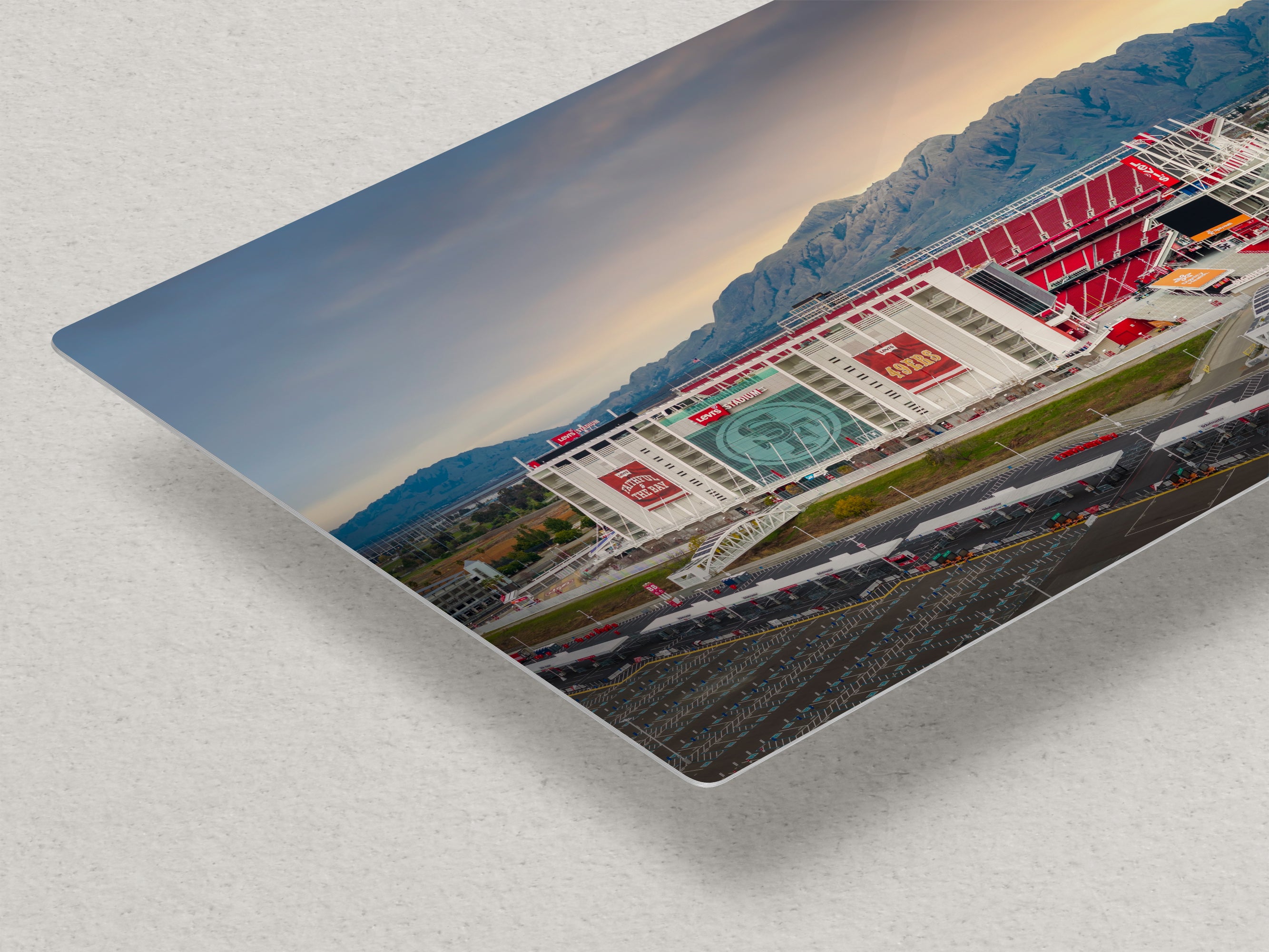 a large stadium with a mountainous backdrop, featuring a large sign with the text "S" prominently displayed.