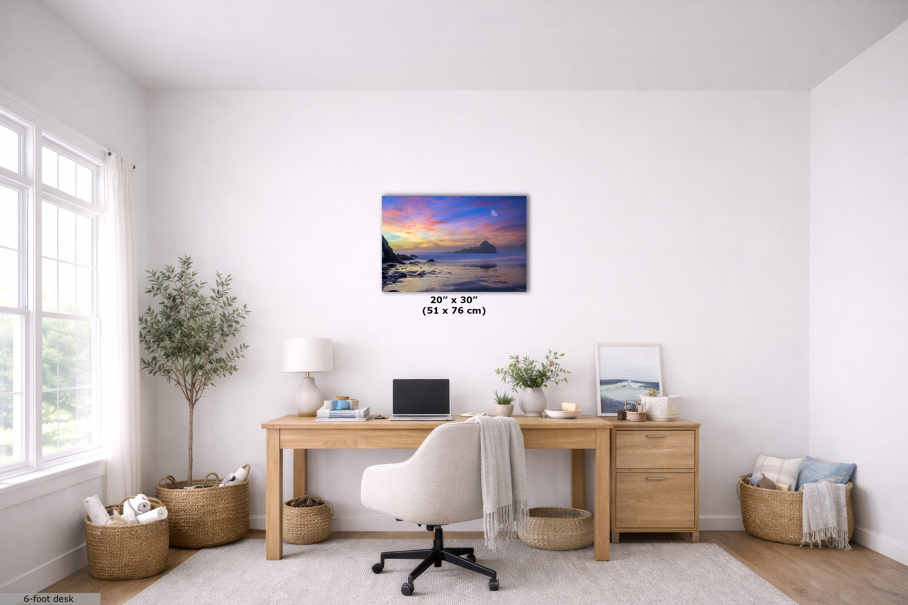 A 20" x 30" canvas print of a colorful sunset over water is displayed on a white wall in a bright, modern home office setting with a wooden desk, white chair, and plants.