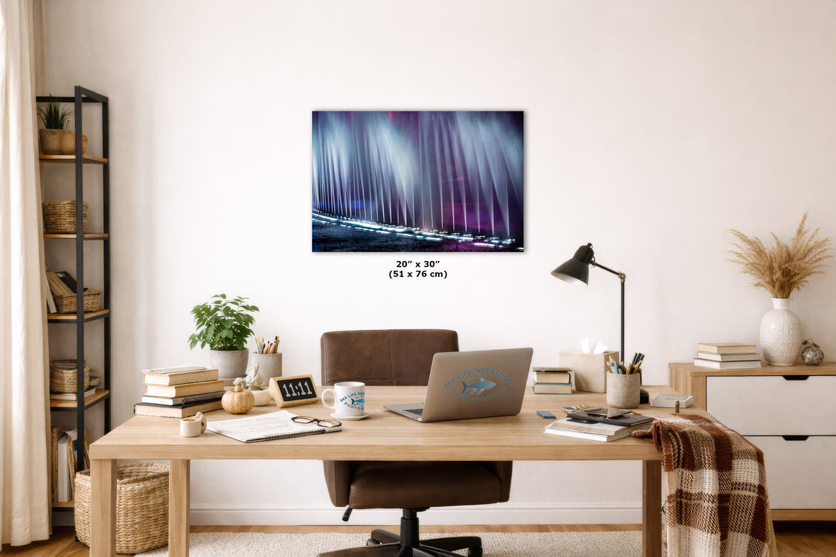 A wall art print depicting a purple and blue abstract artwork, displayed in a modern home office setting above a wooden desk with a laptop and chair.