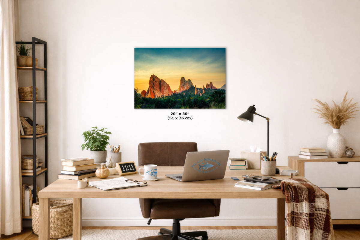 Home office with a desk, laptop, and decor elements, featuring a large wall art print of a mountain landscape.