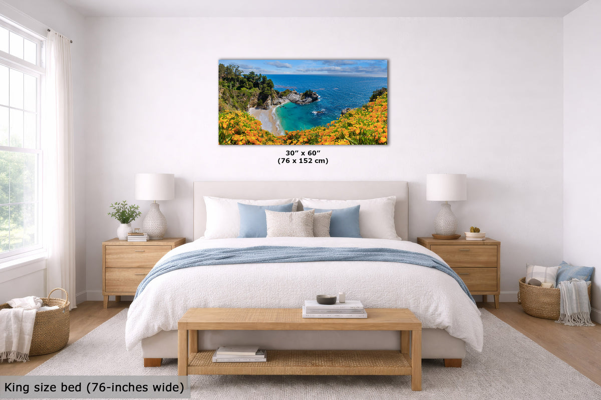 A framed wall art print showing a coastal landscape with blue water, green cliffs, and bright yellow flowers, displayed above a neatly made bed in a bright bedroom. The print includes size text reading 30" x 60" (76 x 152 cm), and the room scene is labeled King size bed (76-inches wide) at the bottom left.