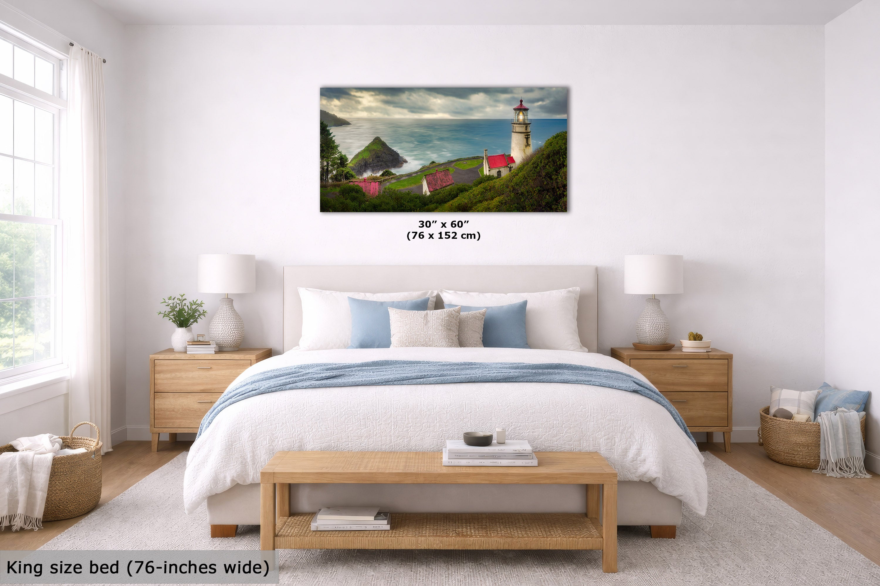 A framed wall art print showing a coastal lighthouse scene with green hills, red-roofed buildings, and a cloudy sky, displayed above a bed in a bright bedroom. Text indicates the print is 30" x 60" (76 x 152 cm) and the bed is king size 76-inches wide.