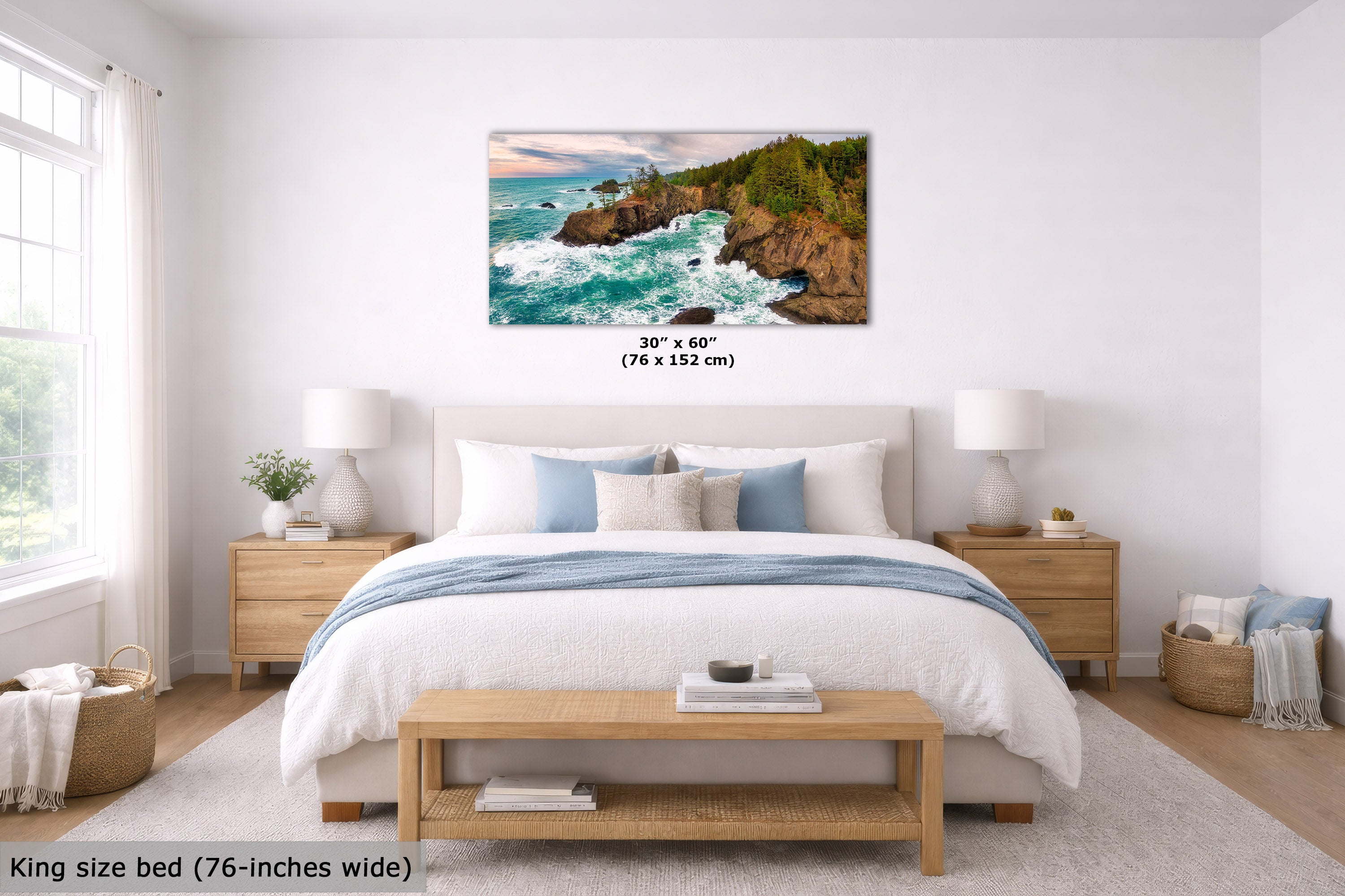 A coastal landscape wall art print showing turquoise waves crashing against rocky cliffs, displayed above a neatly made bed in a bright, modern bedroom. The print includes size text indicating 30 x 60 inches (76 x 152 cm).