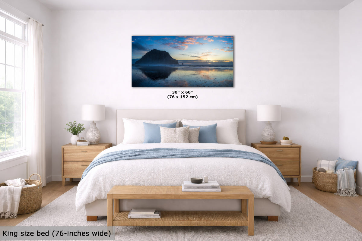 A framed wall art print showing a mountain lake sunset hangs above a neatly made bed in a bright bedroom. The print includes a size label reading 30" x 60" (76 x 152 cm), and the room scene includes a king-size bed and text noting the print is 76-inches wide.