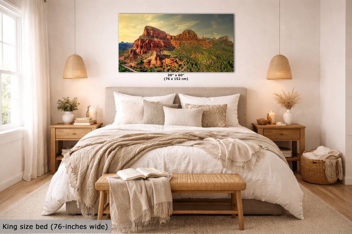 A wall art print showing a desert rock landscape in warm sunset tones, displayed above a neatly made bed in a bright, modern bedroom. The print includes size text reading 30 x 60 inches (76 x 152 cm), and the room scene is labeled as a lifestyle presentation.