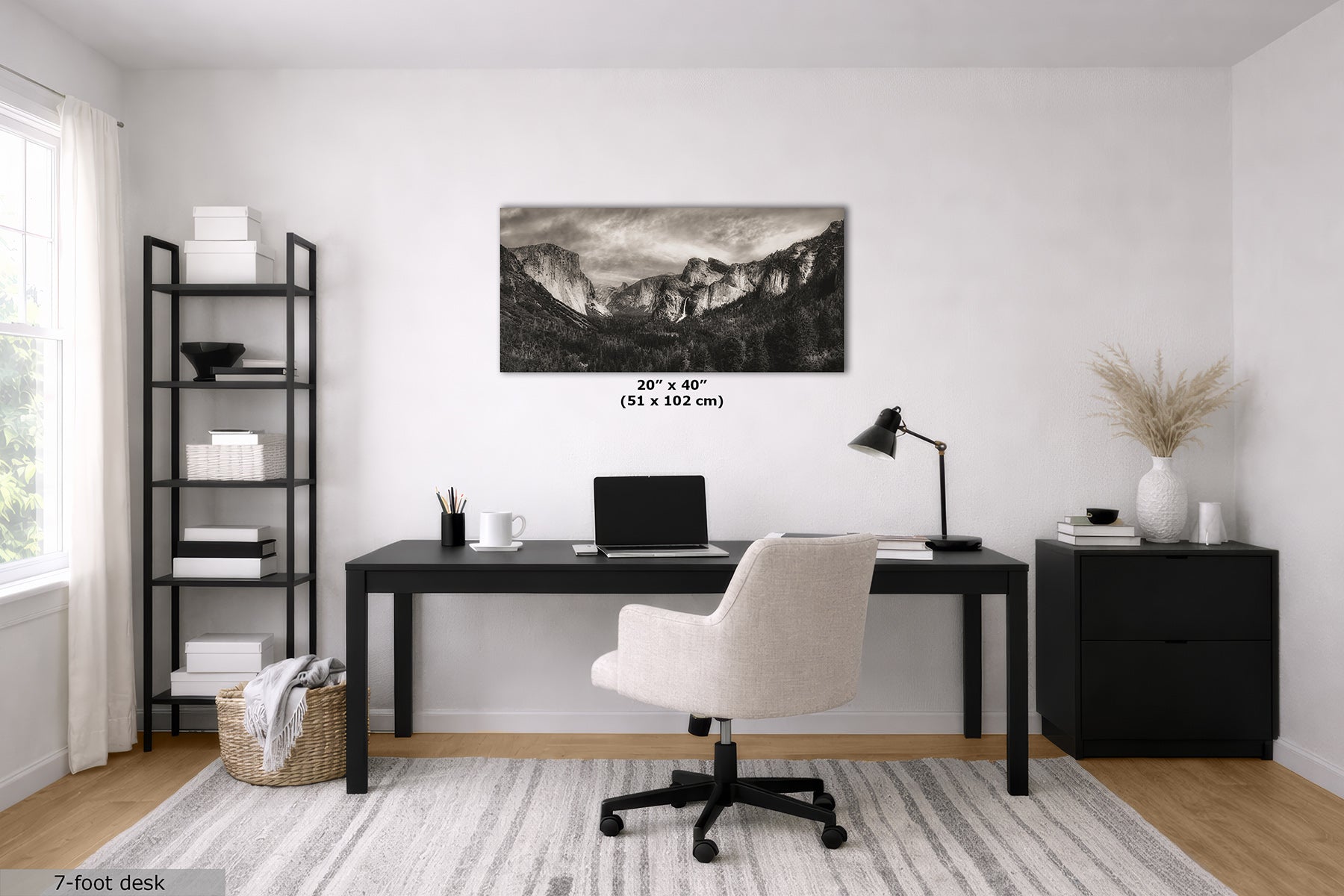 A black and white mountain landscape wall decor of Yosemite Valley from Tunnel View displayed in a modern home office setting above a black desk and white swivel chair, with size text '20" x 40" (51 x 102 cm)' printed directly on the image.