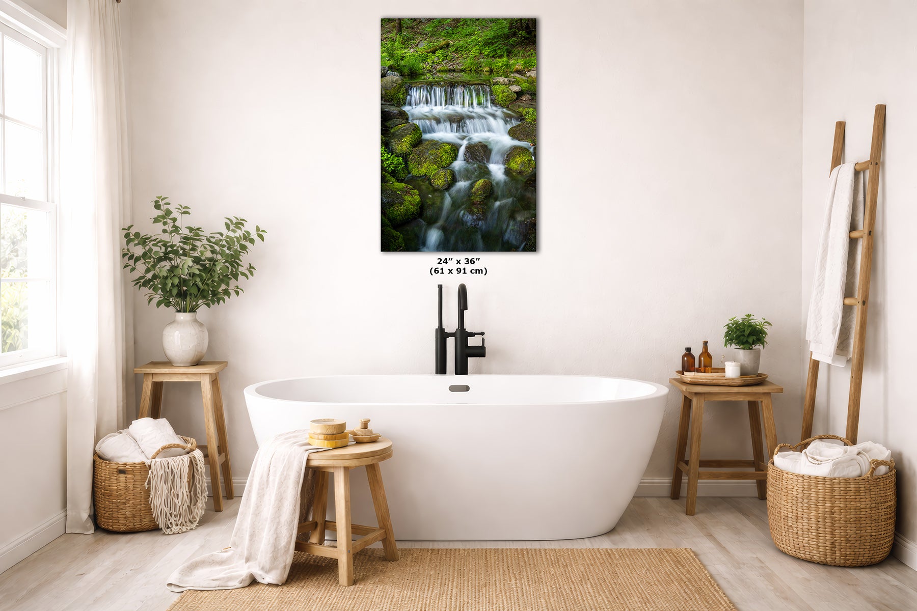 A wall art print depicting a lush green waterfall and mossy rocks, displayed above a white freestanding bathtub in a bright, modern bathroom with wooden stools, woven baskets, and natural light.