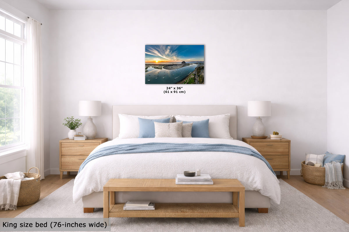 A wall art print showing a sunset over calm water, displayed above a neatly made bed in a bright, modern bedroom. The print includes size text reading 24" x 36" (61 x 95 cm), and the room scene includes a text overlay noting the bed is king size (76-inches wide).