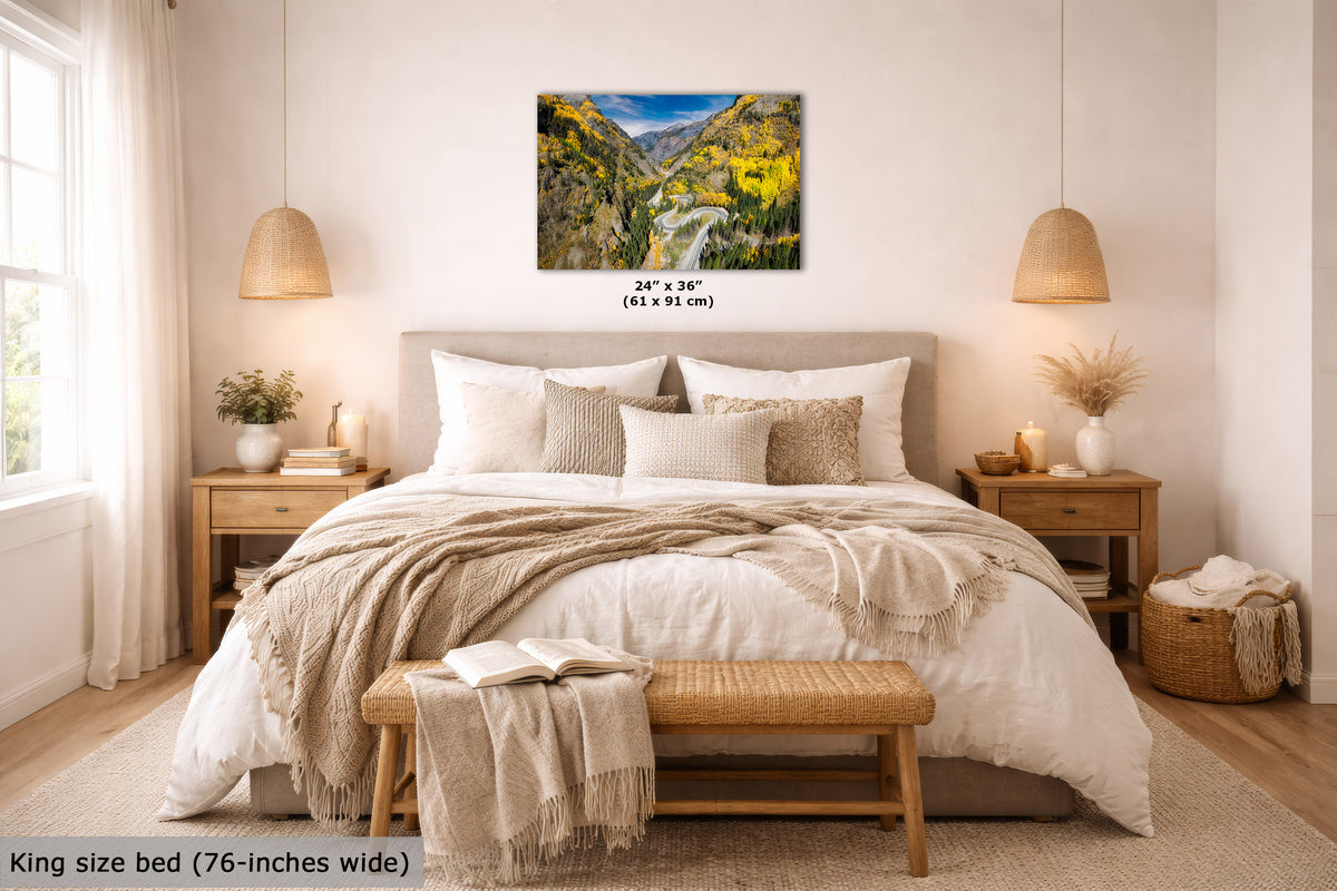 A wall art print showing a colorful mountain valley landscape hangs above a neatly made bed in a bright, modern bedroom. The print includes size text reading 24 x 36 inches (61 x 91 cm), and the room scene also includes a text label at bottom left stating king size bed (76-inches wide).