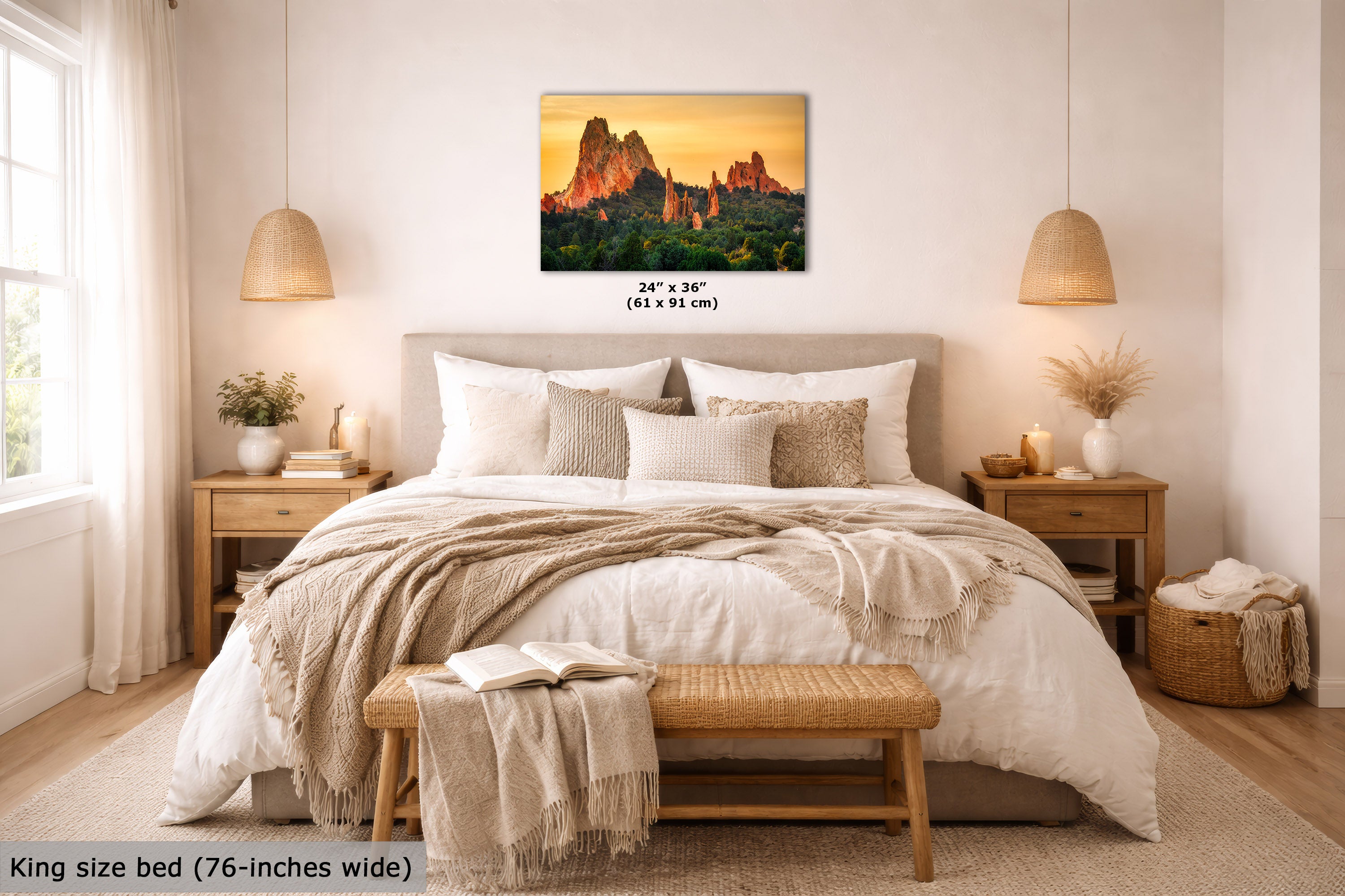 A wall art print showing a desert rock landscape at sunset hangs above a neatly made bed in a warm, modern bedroom. The print includes size text reading 24 x 36 inches, and the room scene is styled with bedding, bedside tables, lamps, and a bench.