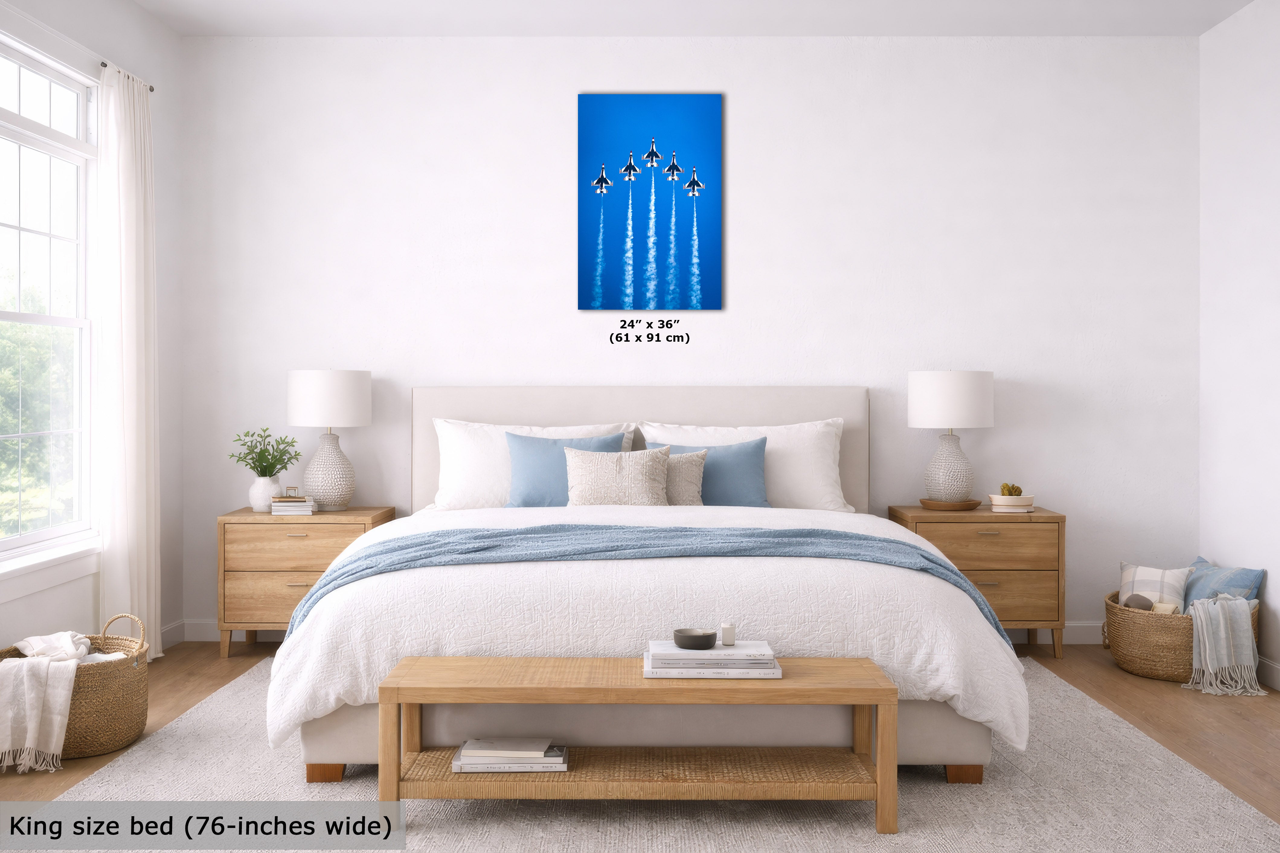A bedroom scene with a bed, nightstands, lamps, and a blue wall art print centered above the headboard. The print shows five jets flying upward on a bright blue background, with size text below it.