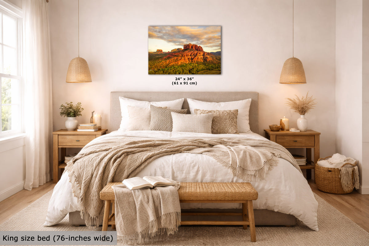 Bedroom with a king-size bed, wooden bench, and wall art of a sunset over a desert landscape.