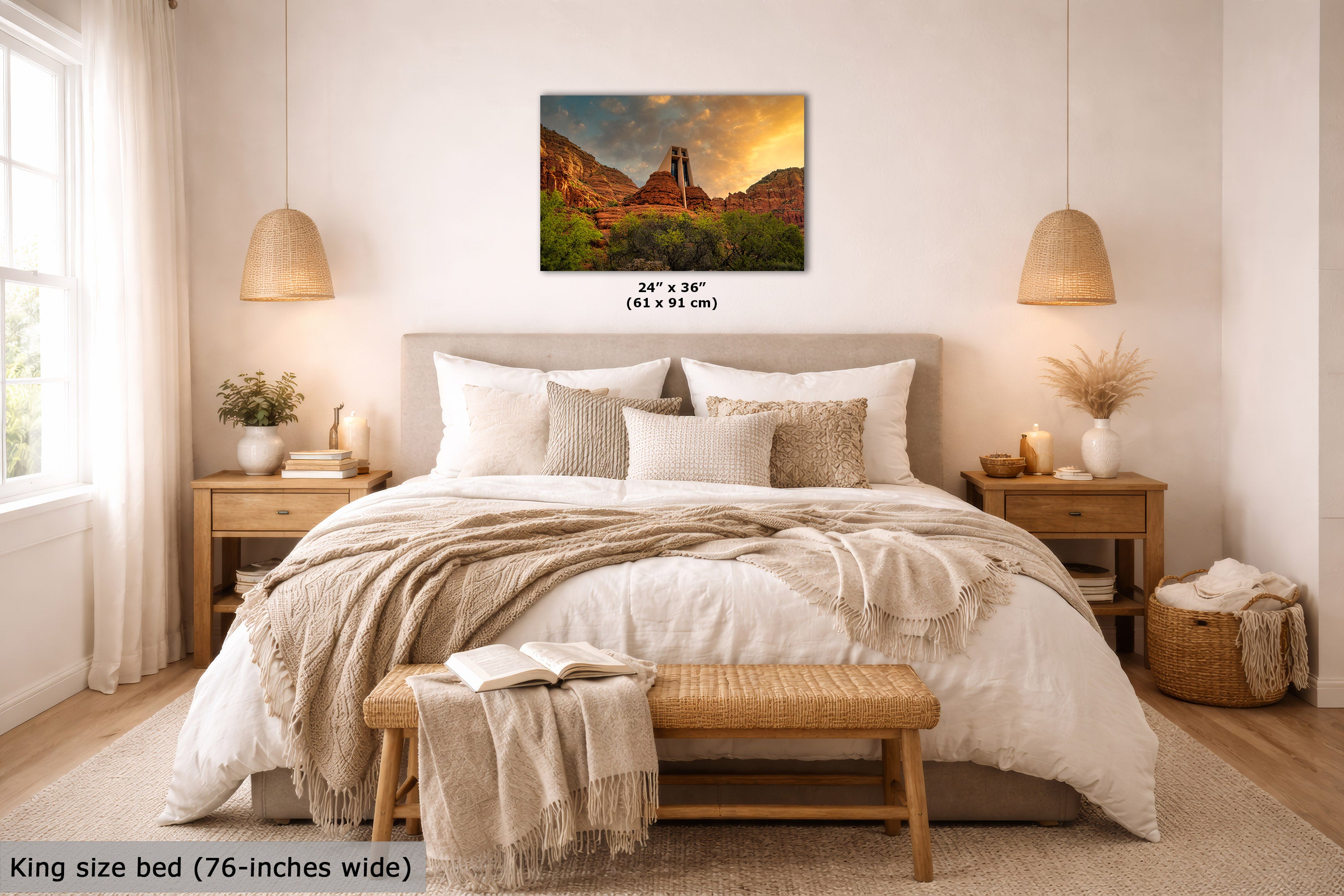 A wall art print showing a desert canyon landscape with a tower under a dramatic sunset sky, displayed above a neatly made bed in a bright, modern bedroom. The print includes size text reading 24 x 36 inches (61 x 91 cm).