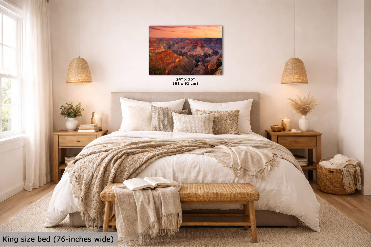 A wall art print showing a colorful canyon landscape at sunset, displayed above a neatly made bed in a bright, modern bedroom. The print includes size text reading 24" x 36" (61 x 91 cm) and a text overlay at the bottom left stating King size bed (76-inches wide).